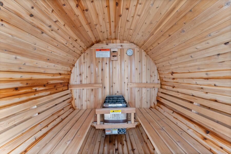 Wooden sauna interior in a Truckee vacation rental, featuring benches and a heater in a barrel-shaped room.