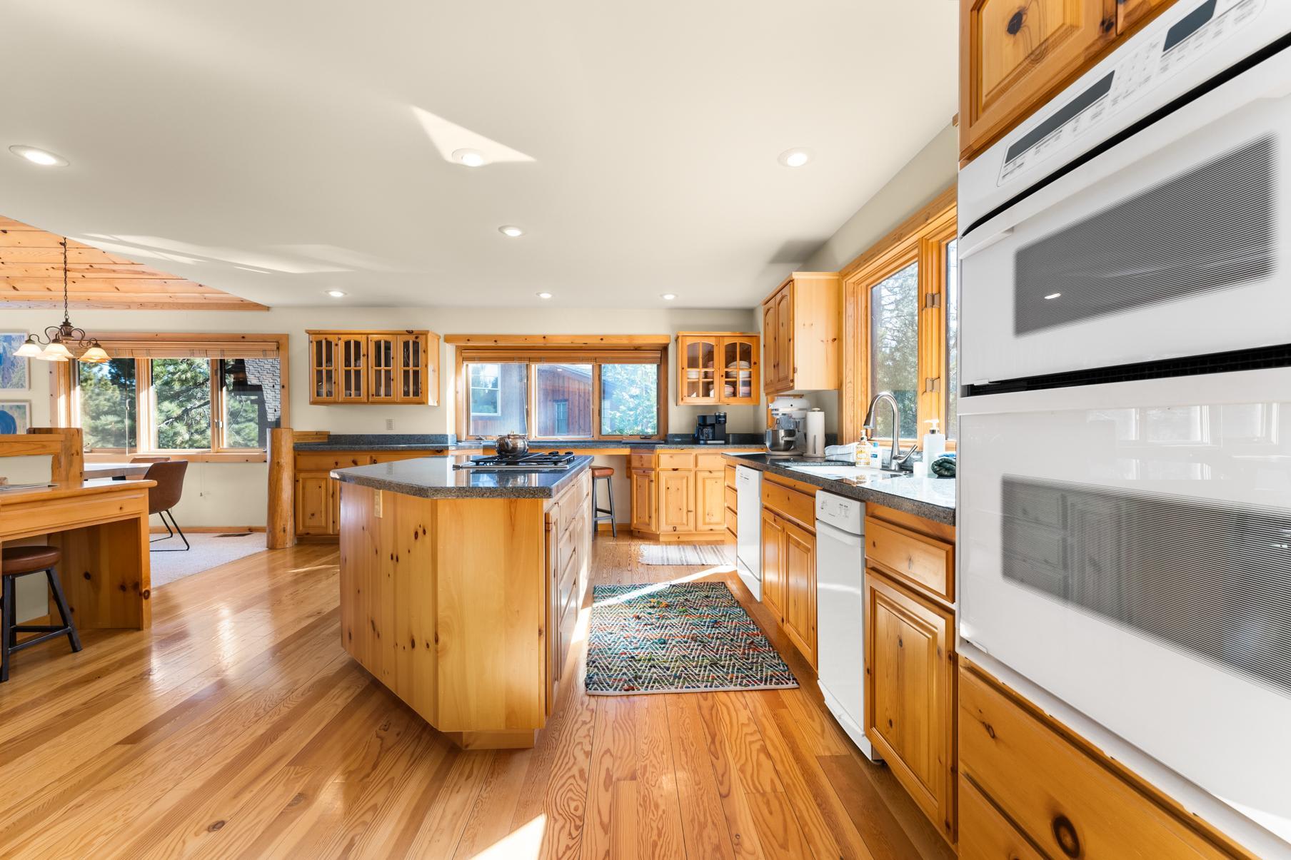 Spacious kitchen in a Truckee vacation rental, featuring wooden cabinets, island, and large windows.