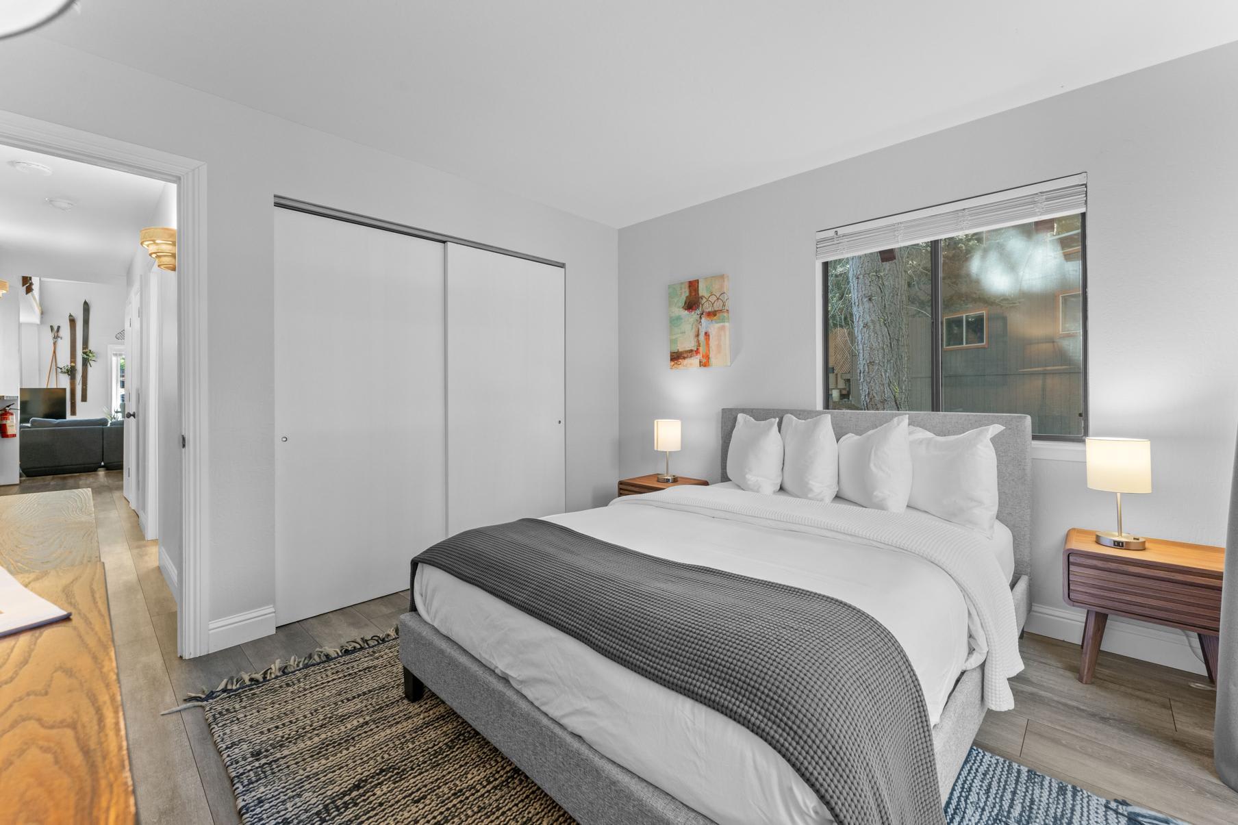 Modern bedroom in a Tahoe Vista vacation rental with a cozy bed, soft lighting, and stylish decor.