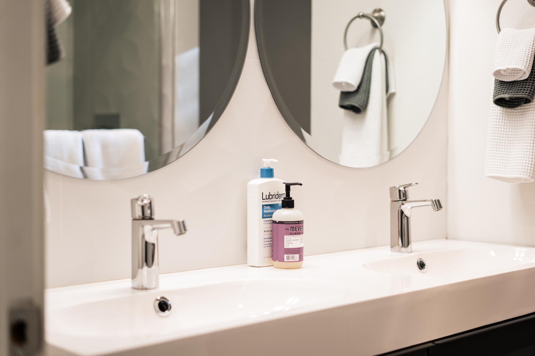 Modern bathroom with dual sinks and round mirrors in a Tahoe Vista vacation rental.