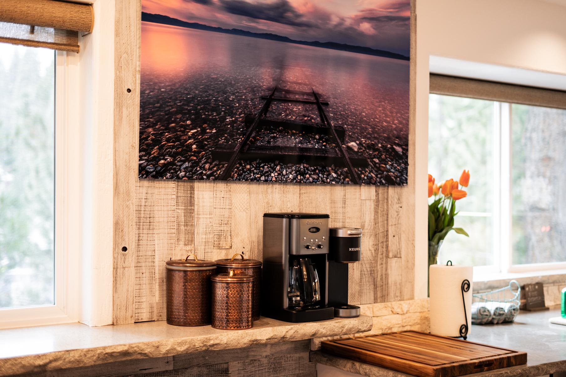 Cozy kitchen corner in a Truckee vacation rental with a coffee maker, tulips, and scenic artwork on the wall.