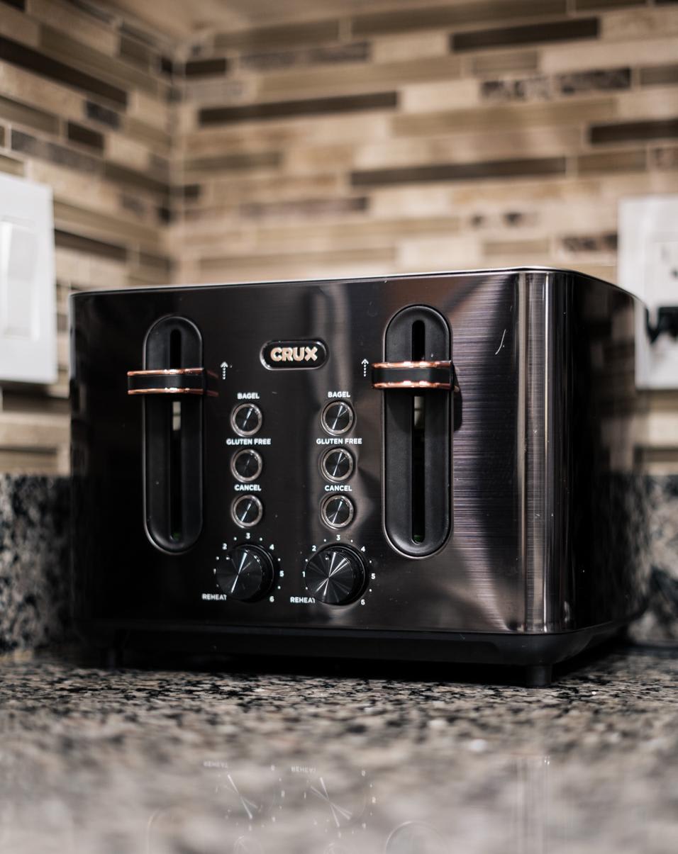 A sleek toaster on a granite countertop in a Truckee vacation rental kitchen with modern tiled backsplash.