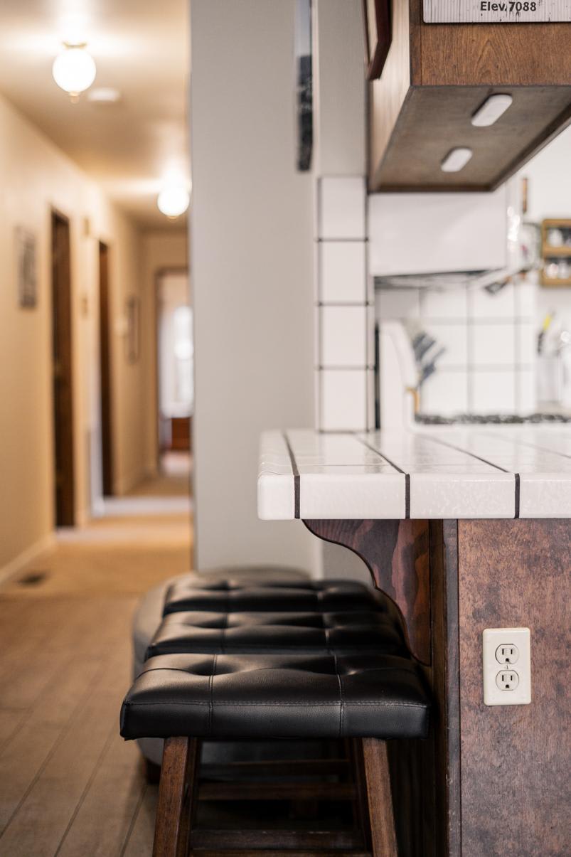 Counter and bar stools in a Truckee vacation rental, featuring a cozy hallway and warm lighting.