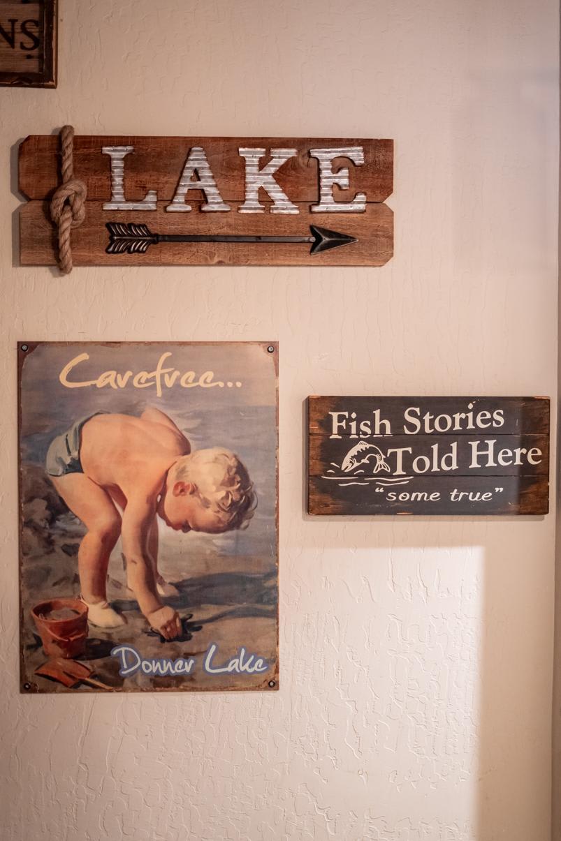 Wall signs in a Truckee vacation rental featuring lake and fishing themes with a vintage beach poster.