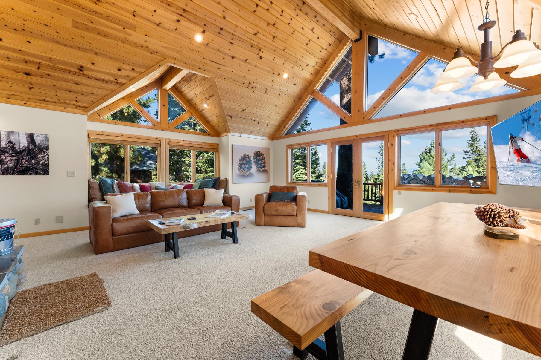 Spacious vacation rental in Truckee with large windows, wood ceiling, and comfortable seating in a bright living area.