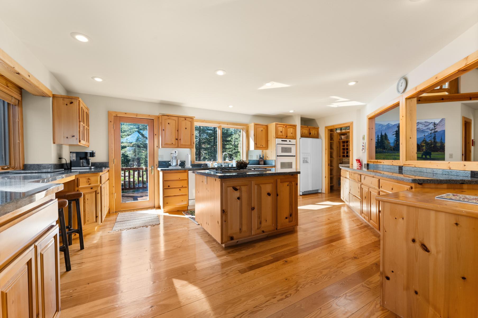 Spacious wooden kitchen with island, sunlight streaming in, part of a vacation rental in Truckee.