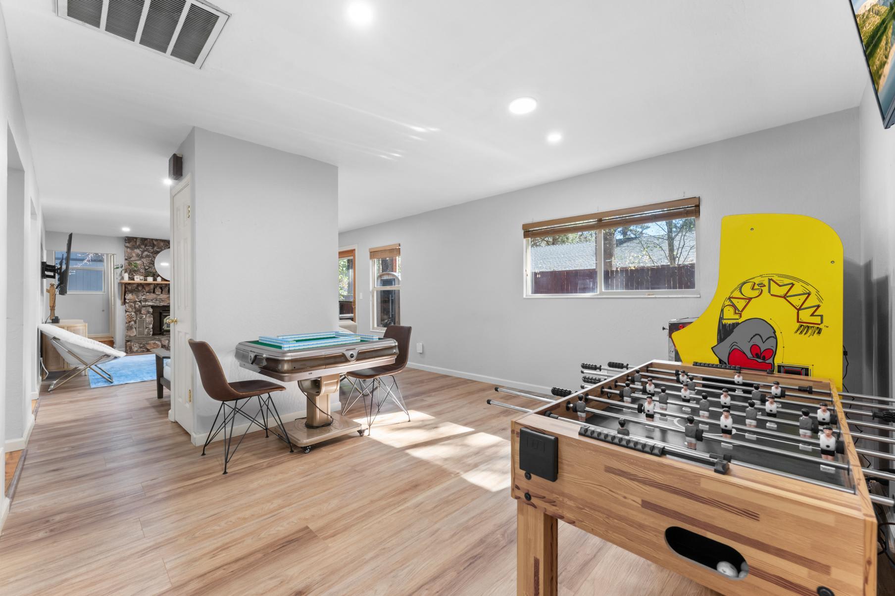 Game room in a Truckee vacation rental with foosball, arcade game, and seating area. Bright, modern decor.