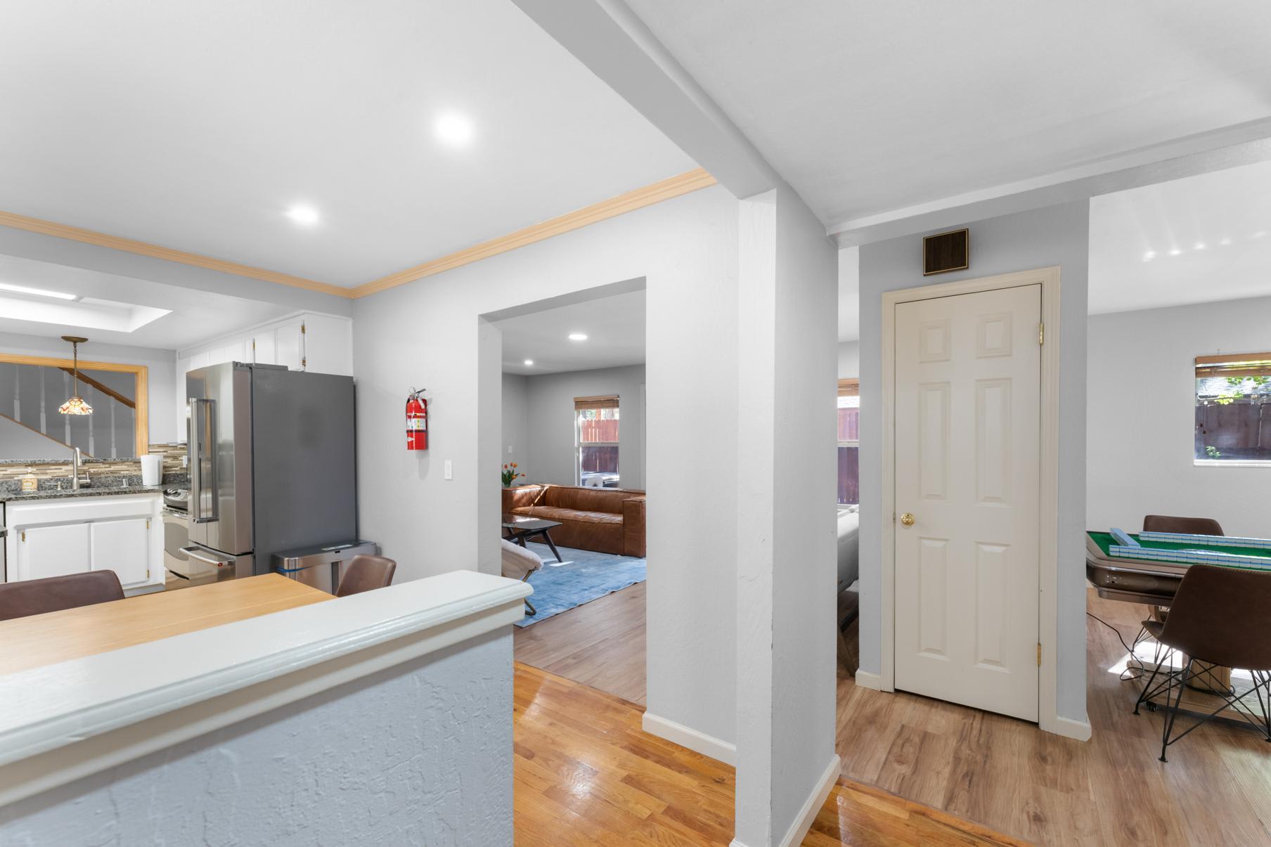 Modern interior of a Truckee vacation rental featuring a kitchen, living area with brown sofa, and dining space.