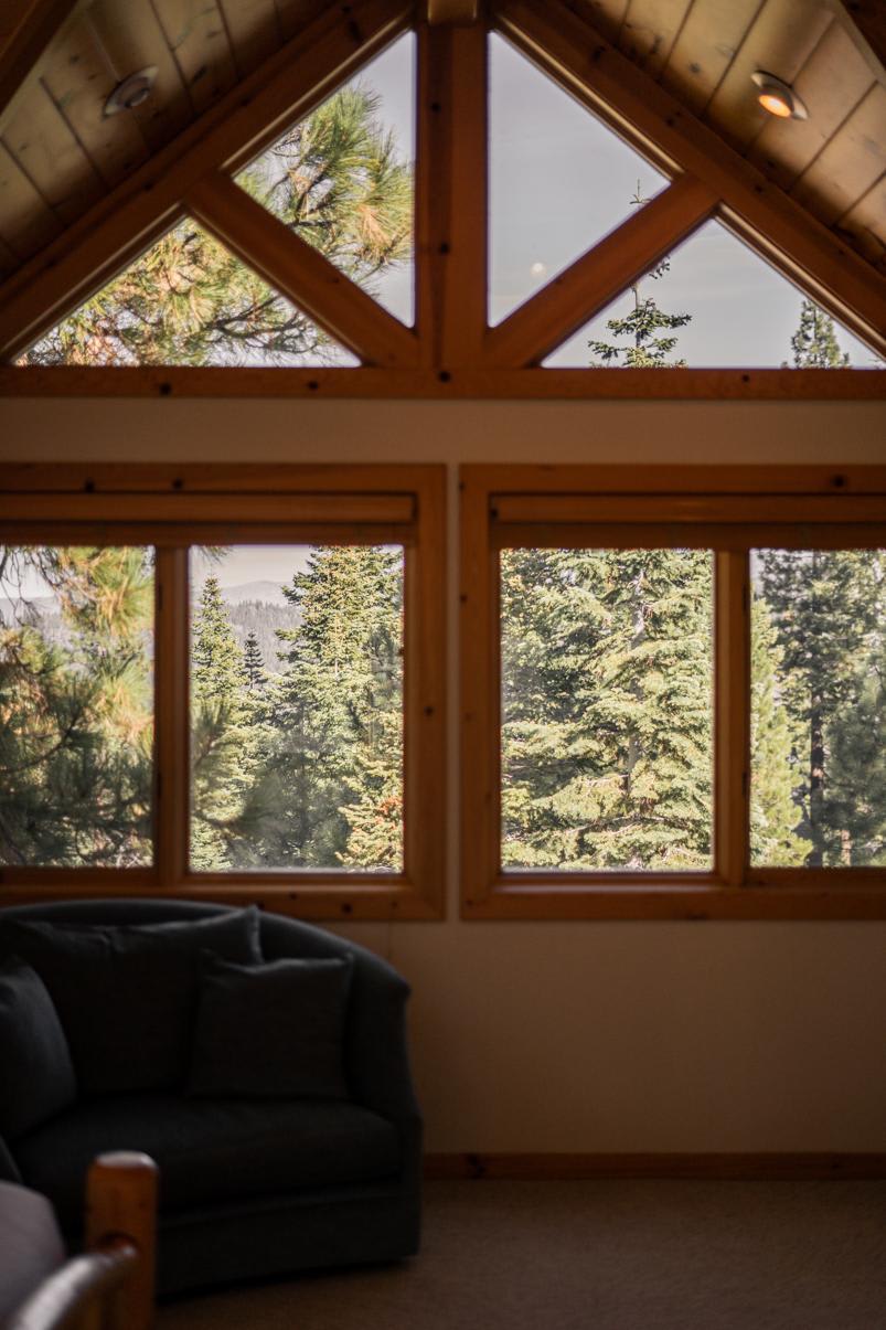 Large windows in a Truckee vacation rental showcase breathtaking forest views.