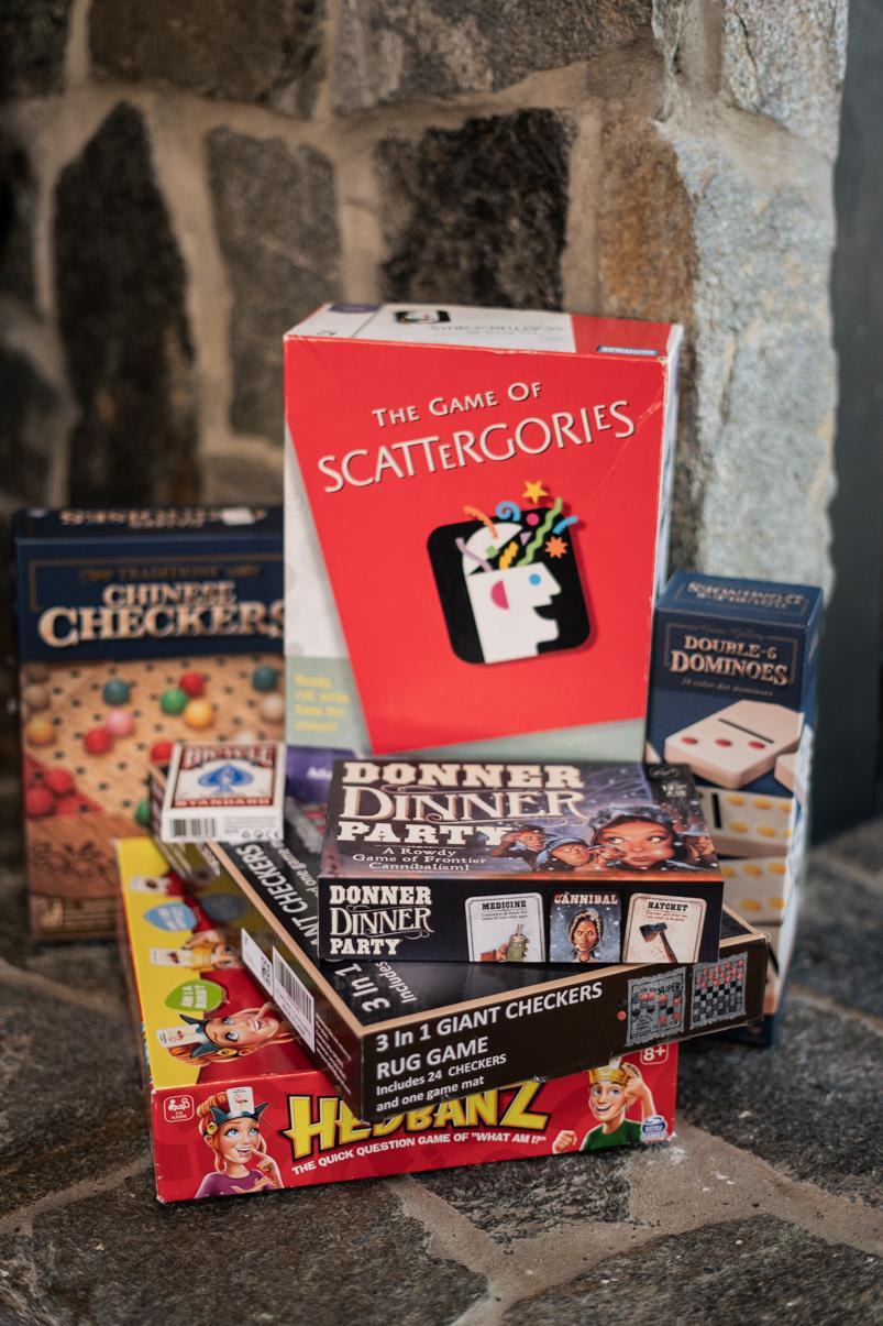 Board games stacked in a Truckee vacation rental, including Scattergories, Chinese Checkers, and Donner Dinner Party.