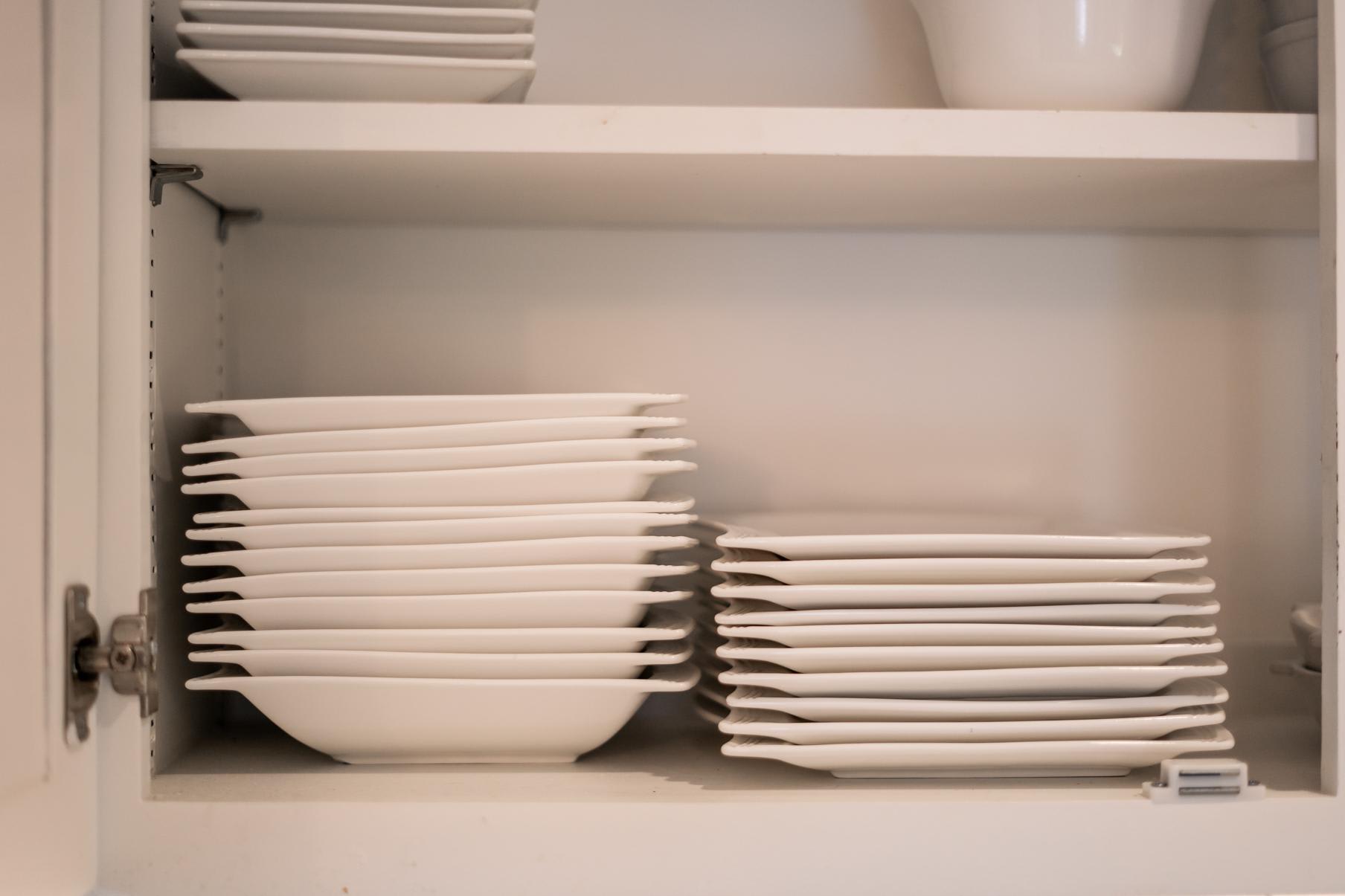 Stacked white dishes and bowls in a cabinet at a Truckee vacation rental.