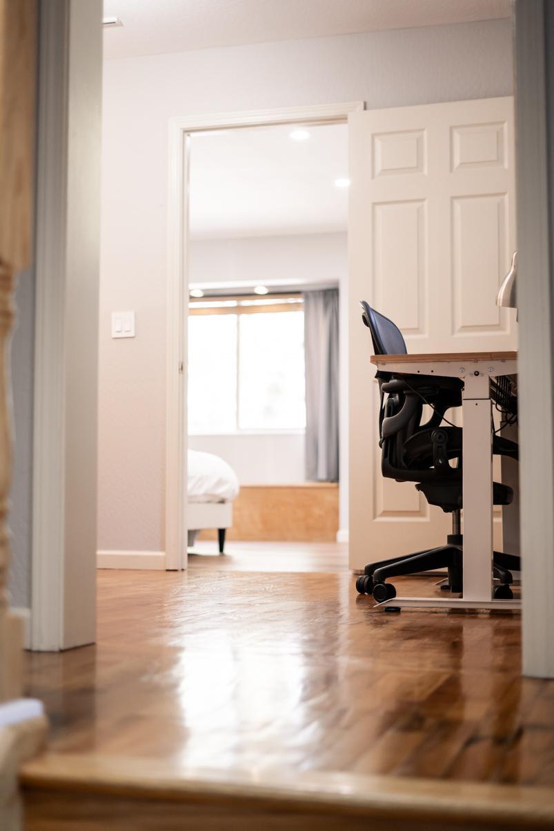 Modern Truckee vacation rental featuring an office chair and a glimpse of a sunlit bedroom with wooden floors.