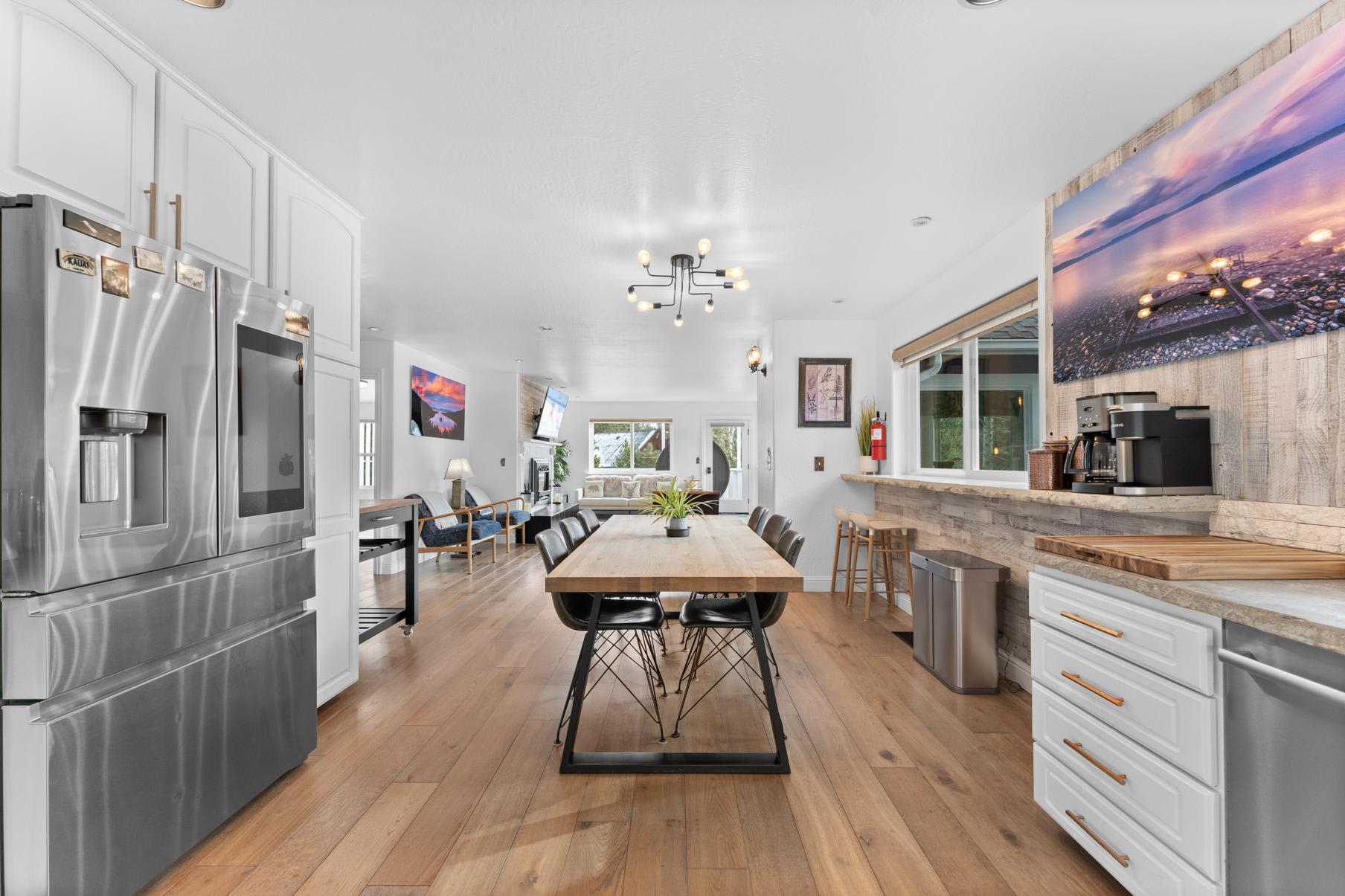 Modern kitchen in a Truckee vacation rental featuring a sleek design, large dining table, and stainless steel appliances.