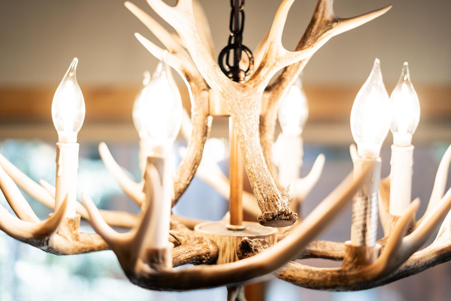 Rustic antler chandelier glowing inside a Truckee vacation rental, creating a cozy ambiance.