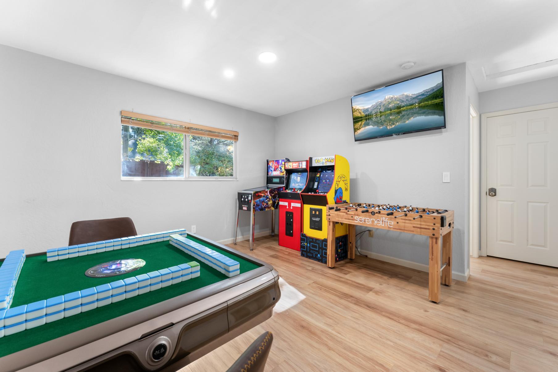 Game room in a Truckee vacation rental with arcade machines, foosball, and a Mahjong table.