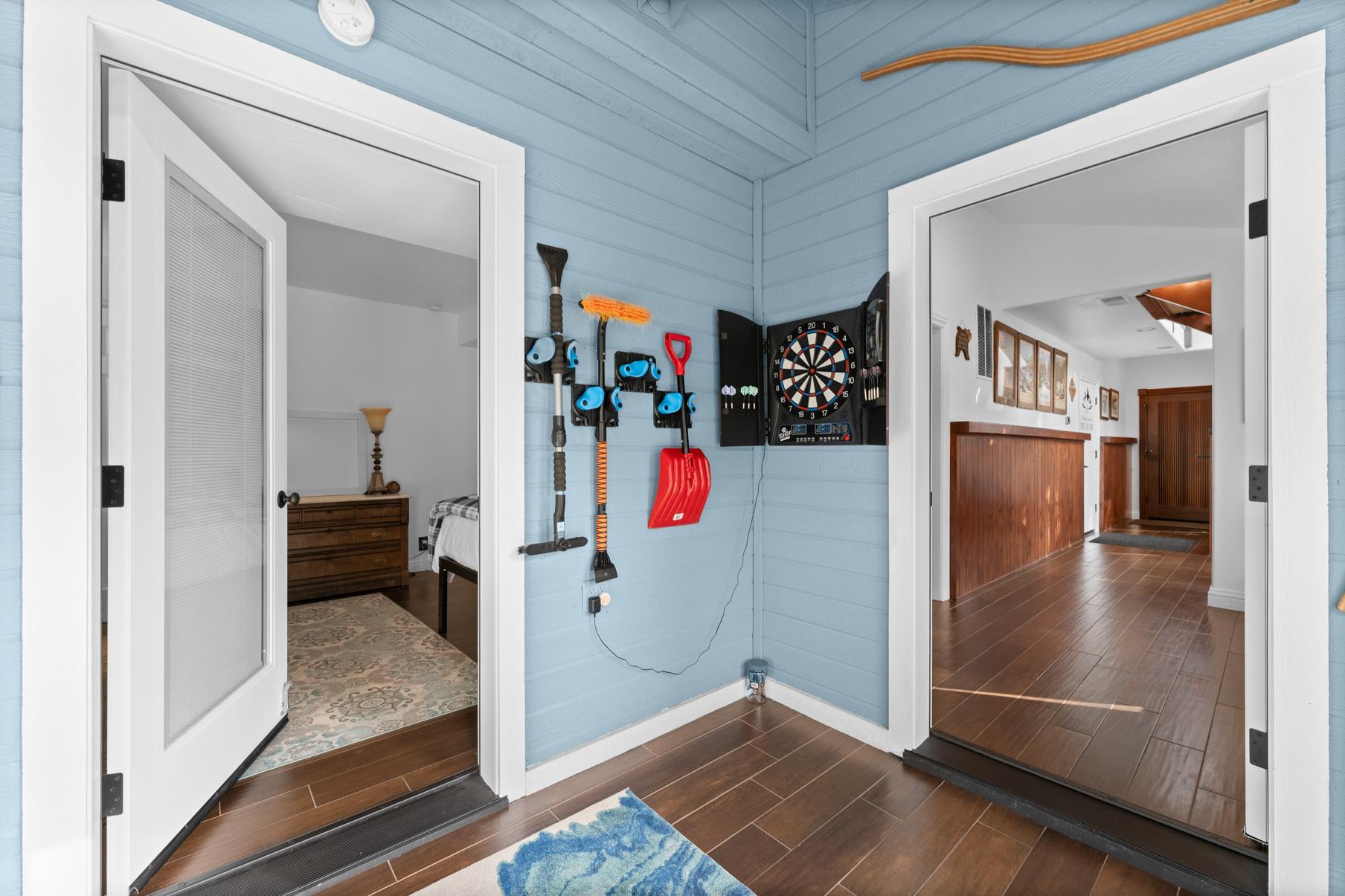 Spacious Truckee vacation rental with blue walls, dartboard, and hallway view featuring doors to bedroom and living area.