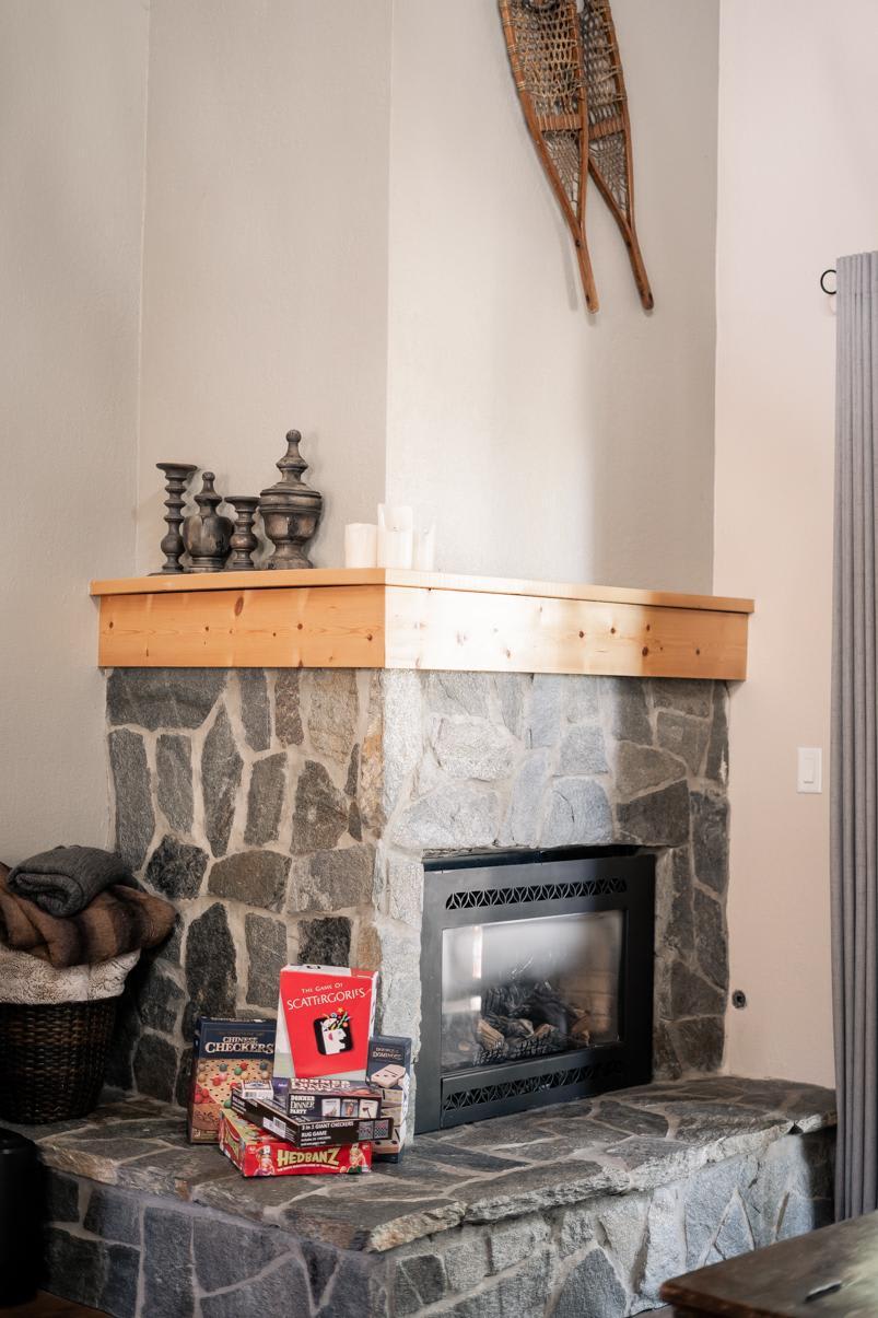 Cozy stone fireplace in Truckee vacation rental with board games and rustic decor accents, capturing a relaxed vibe.