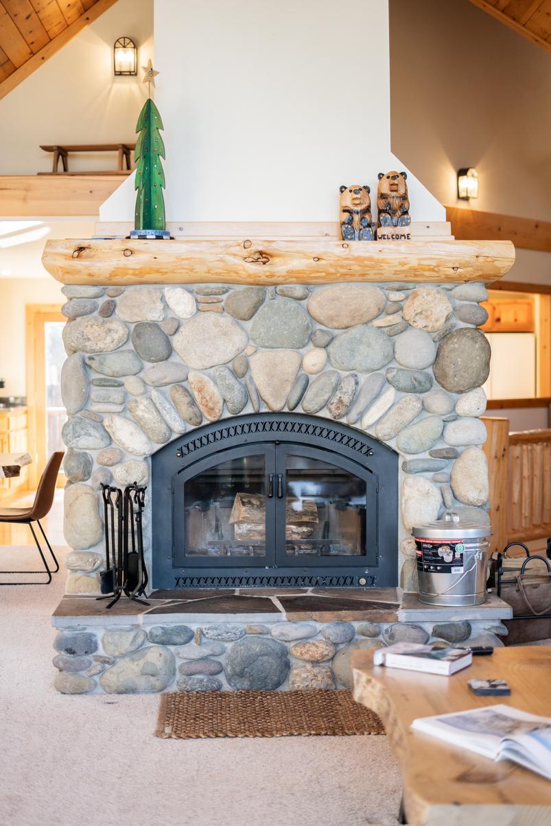 Stone fireplace in Truckee vacation rental, decorated with wooden accents and cozy living area in view.