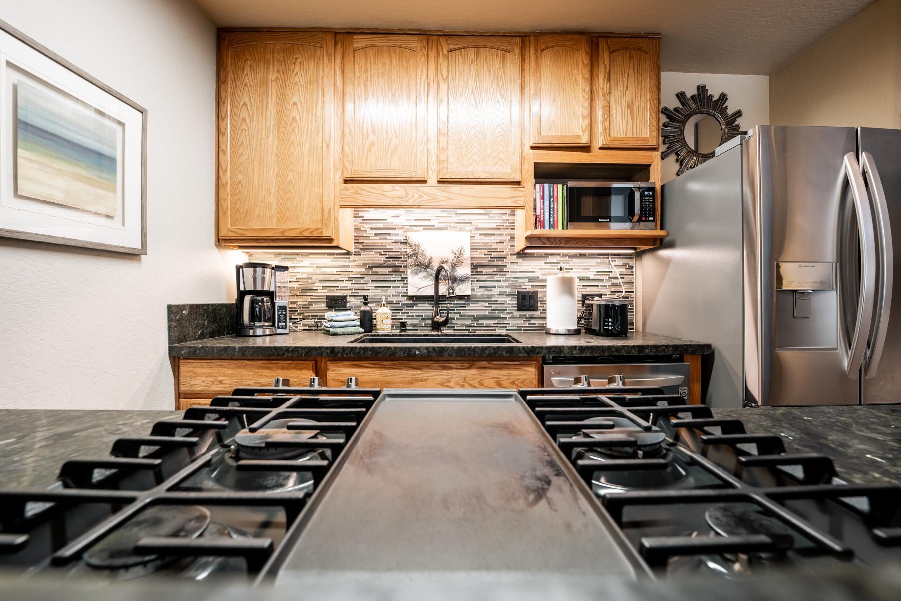 Modern kitchen in a Truckee vacation rental with wood cabinets, stainless steel appliances, and a gas stove.