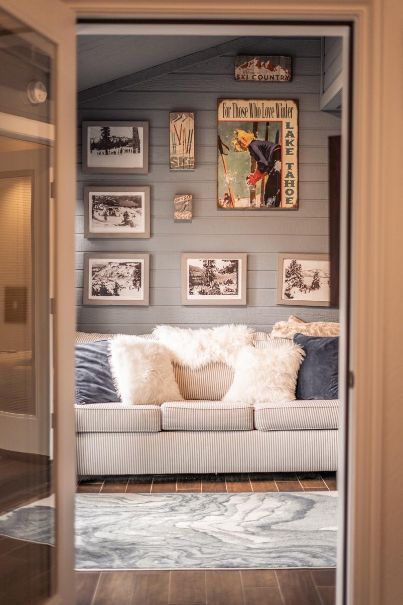 Cozy living area in a Truckee vacation rental, featuring a sofa, fluffy pillows, and winter-themed wall art.