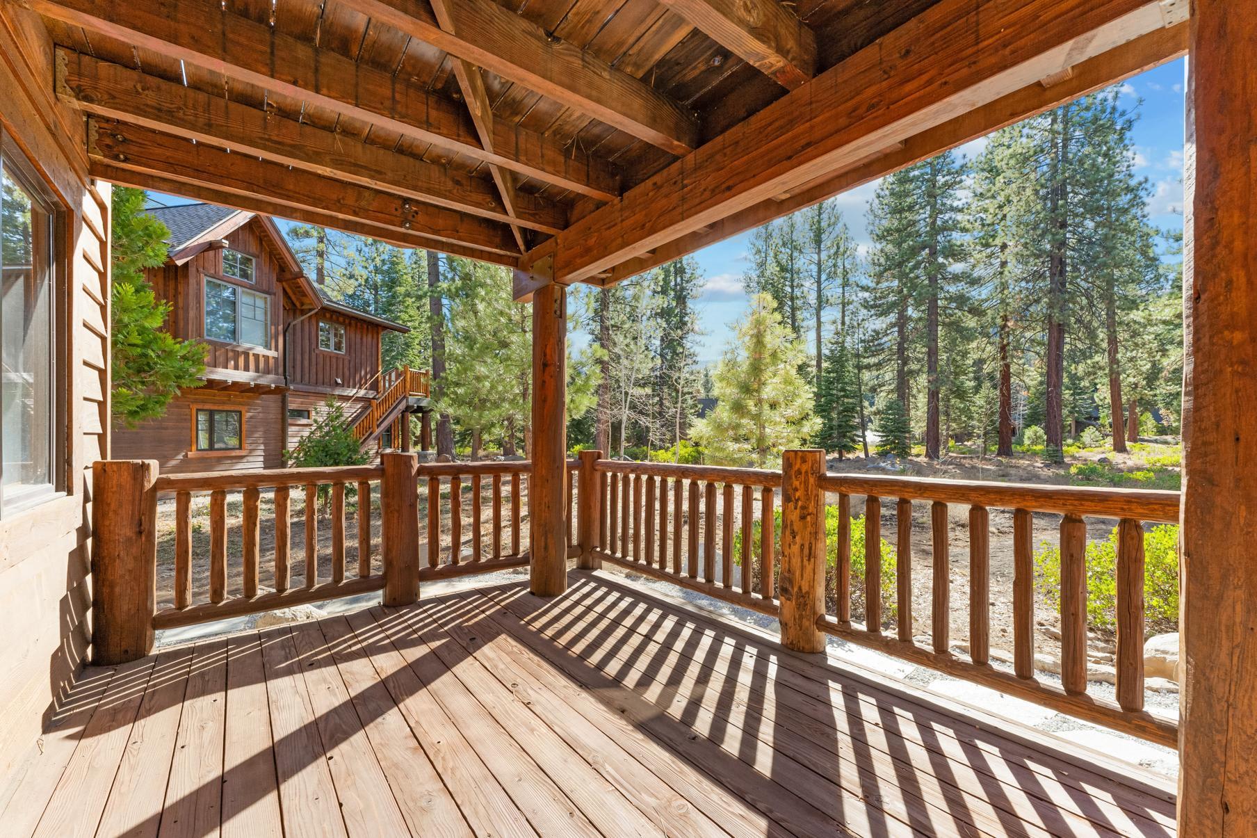 Rustic wooden deck of a vacation rental in Truckee, surrounded by tall pine trees and serene forest views.