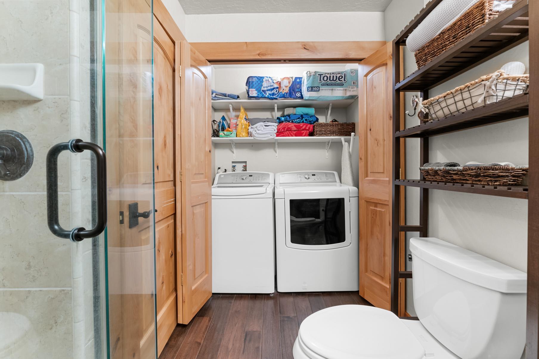 Laundry area in a Truckee vacation rental with washer, dryer, shelving, and bathroom essentials.