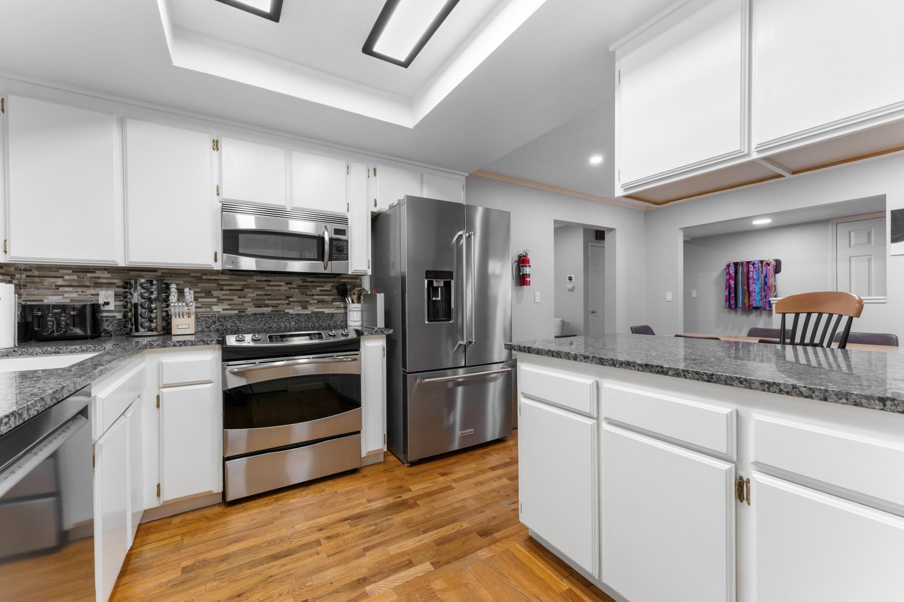 Modern kitchen in a Truckee vacation rental, featuring stainless steel appliances and granite countertops.