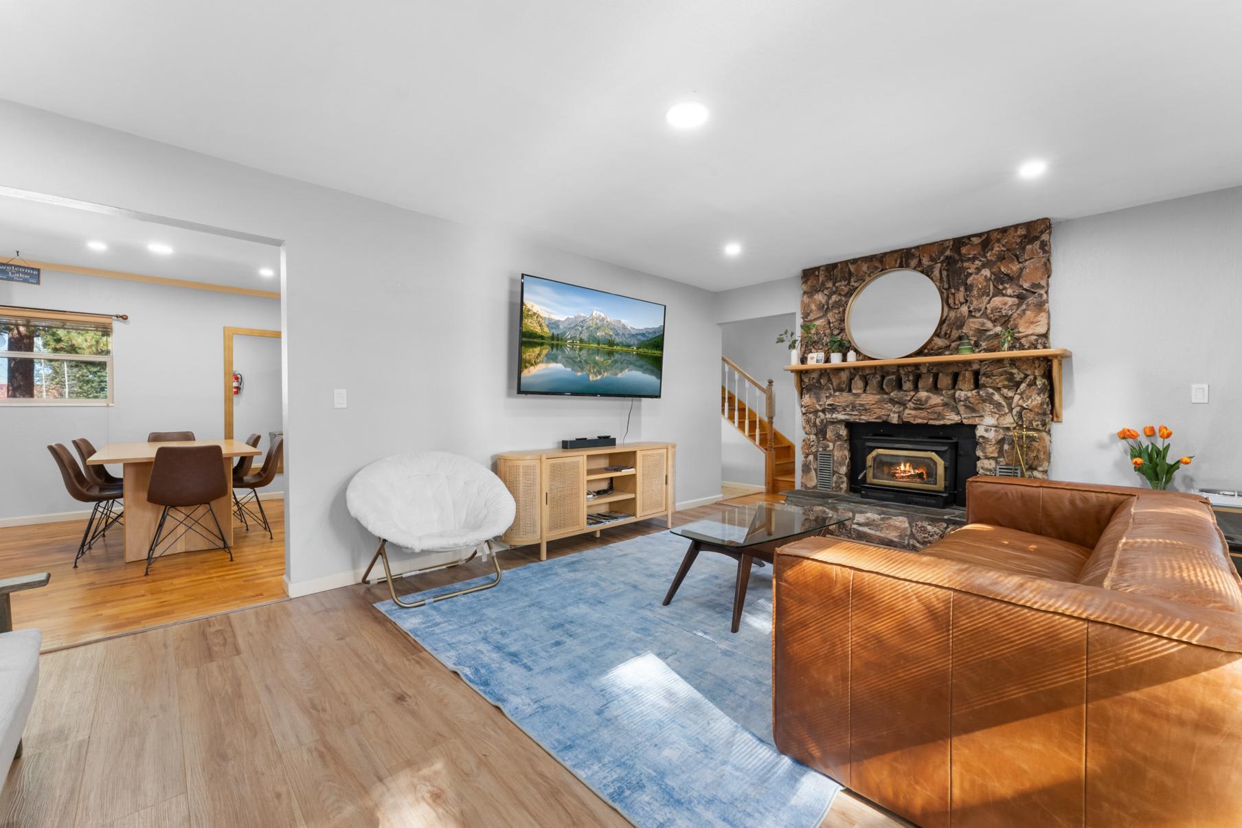 Cozy living room in a Truckee vacation rental, featuring a stone fireplace, leather sofa, and modern decor.