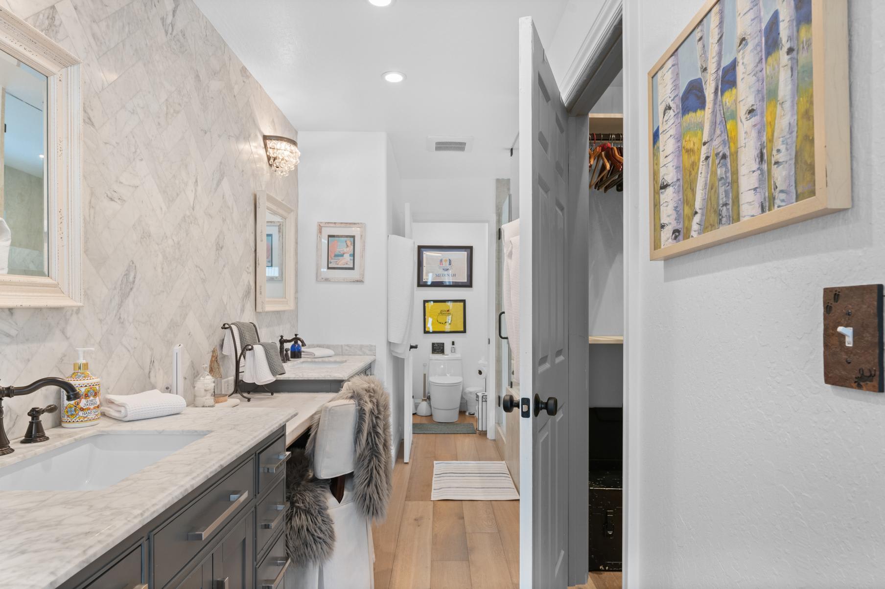 Chic bathroom in a Truckee vacation rental with marble countertops, elegant decor, and a plush-covered chair.