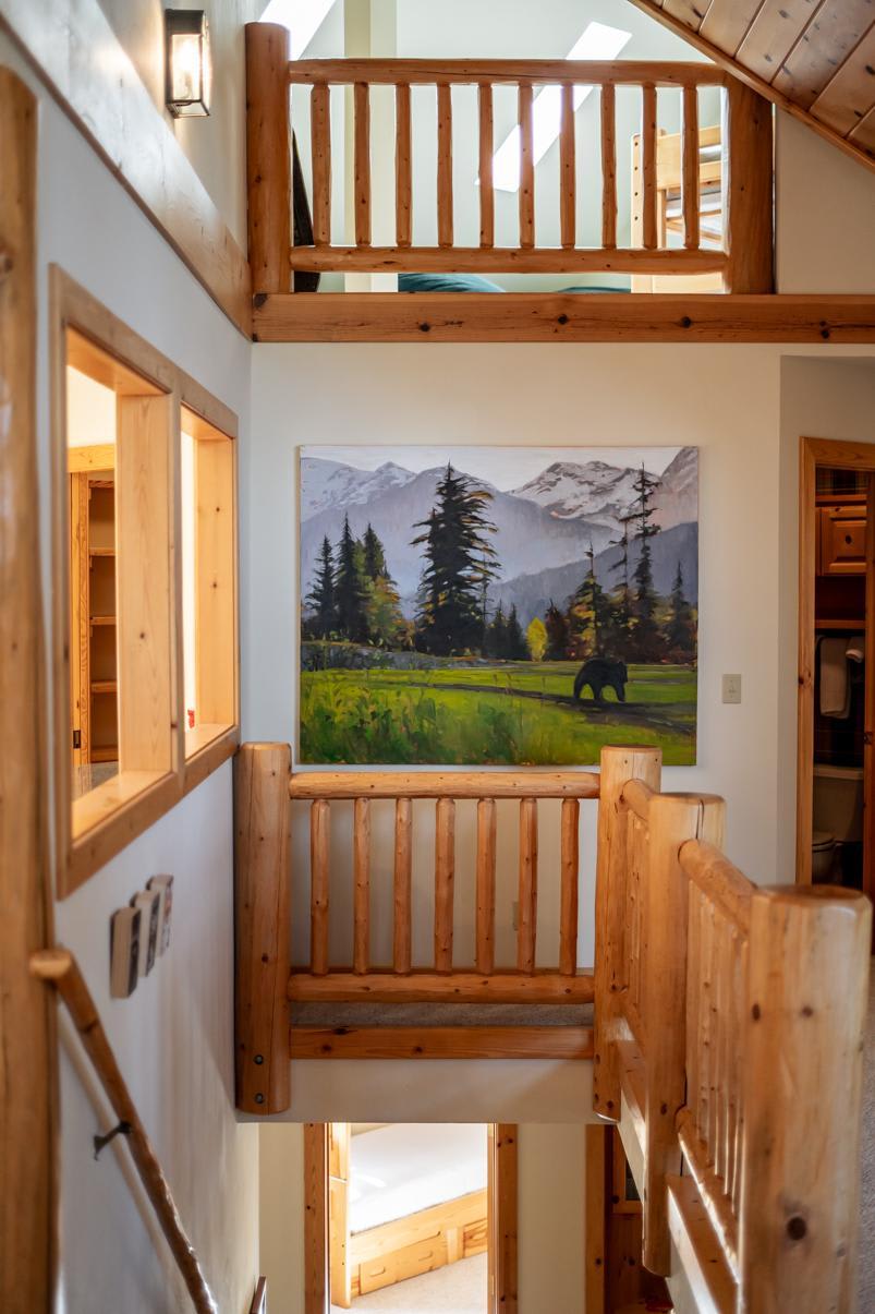 Interior of a Truckee vacation rental with wooden railings and a nature painting of mountains and trees.