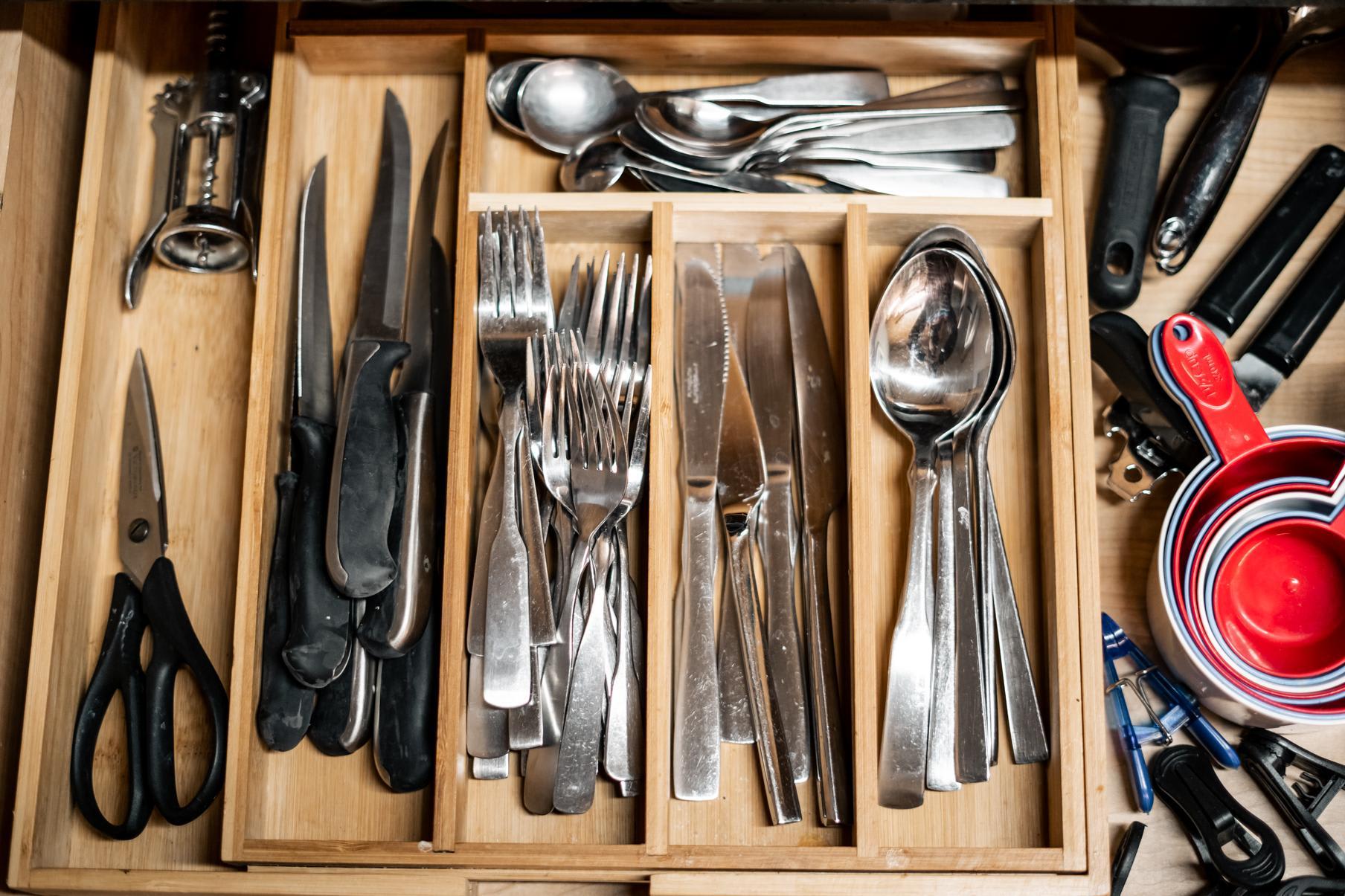 Kitchen drawer with utensils in a Truckee vacation rental, including knives, forks, spoons, scissors, and measuring cups.