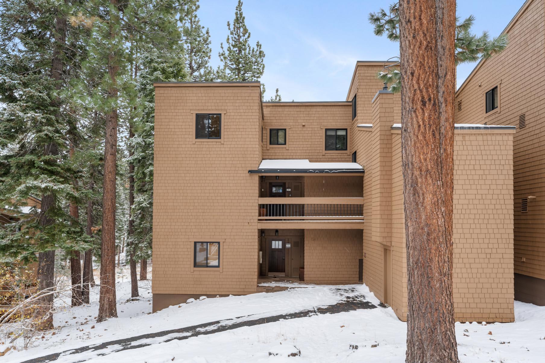 Exterior view of a multi-story vacation rental in snowy Truckee, surrounded by pine trees.