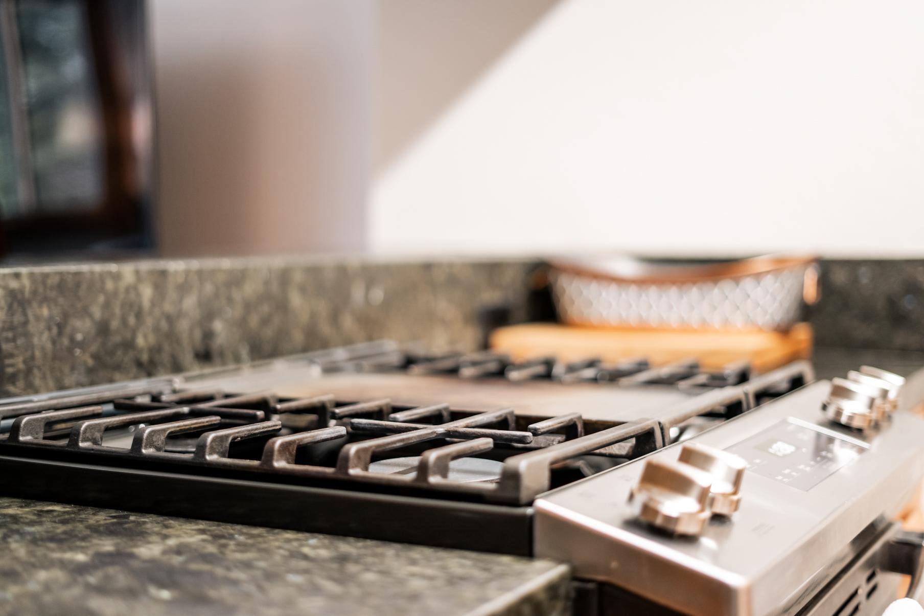 Modern kitchen stove in a Truckee vacation rental, featuring sleek granite countertops and a cozy ambiance.