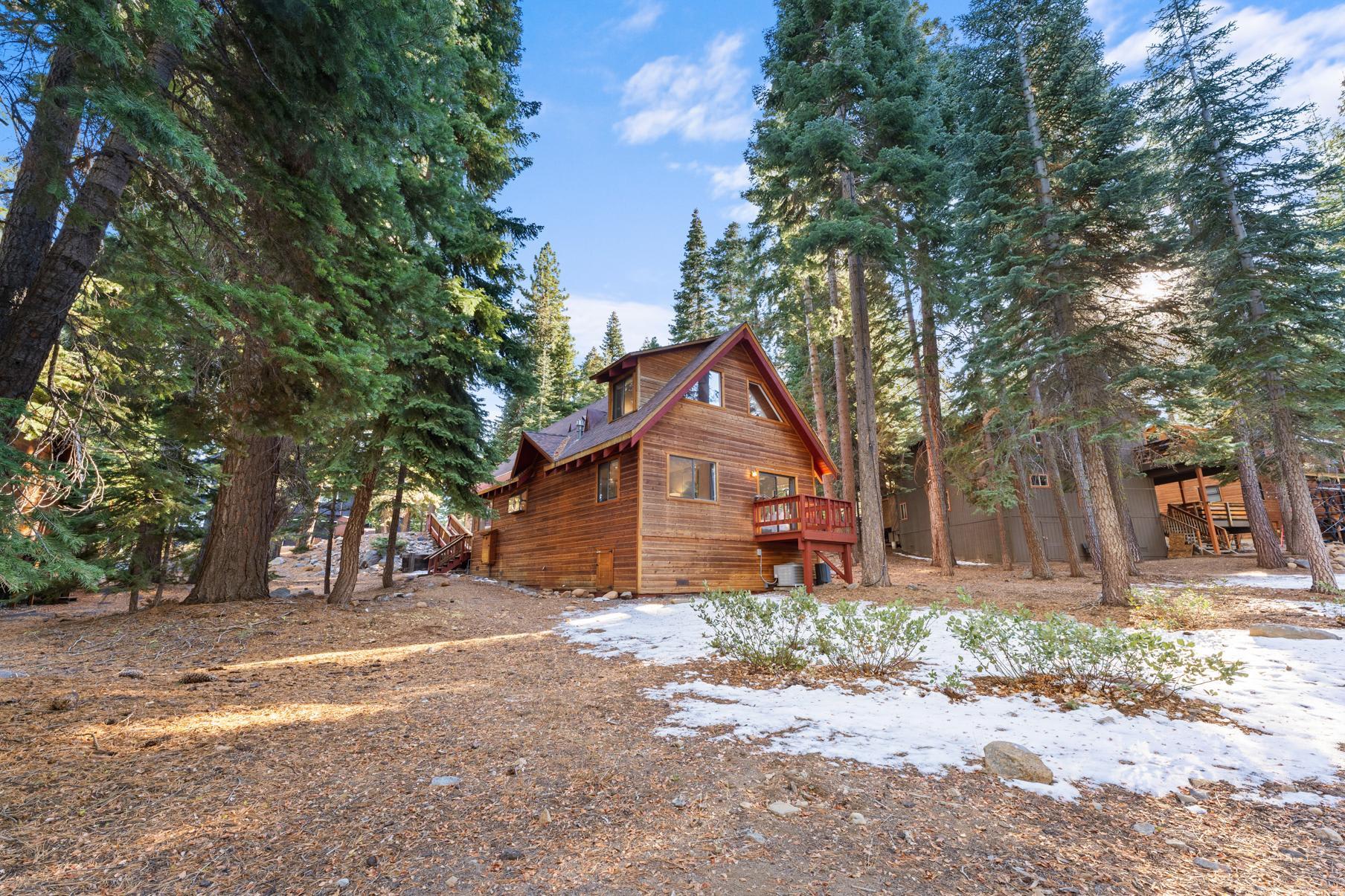 A cozy wood cabin surrounded by tall trees in Tahoe Vista, a charming vacation rental nestled in nature.