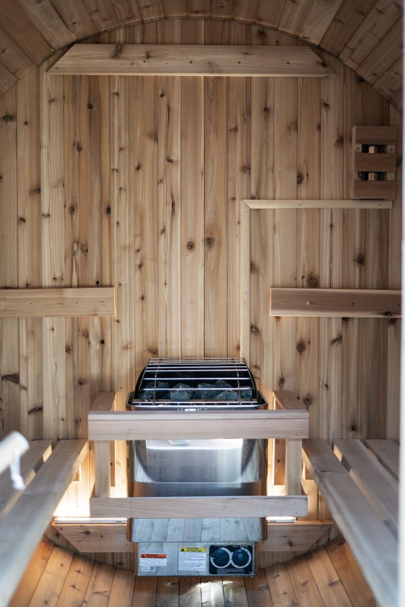 Cozy wood-paneled sauna interior in a Truckee vacation rental, featuring a modern heater with stones.