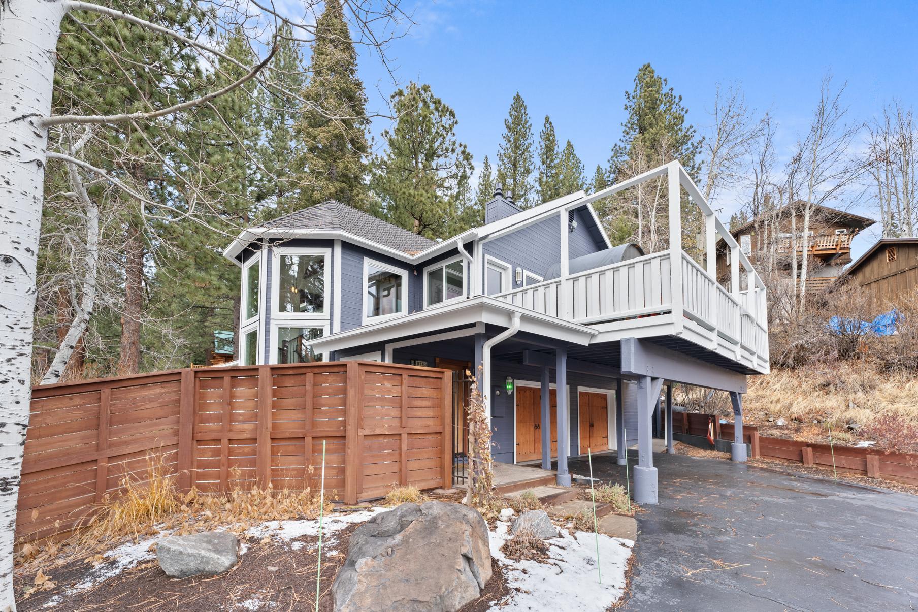 Modern vacation rental in Truckee, featuring a spacious balcony, surrounded by pine trees and snowy landscape.