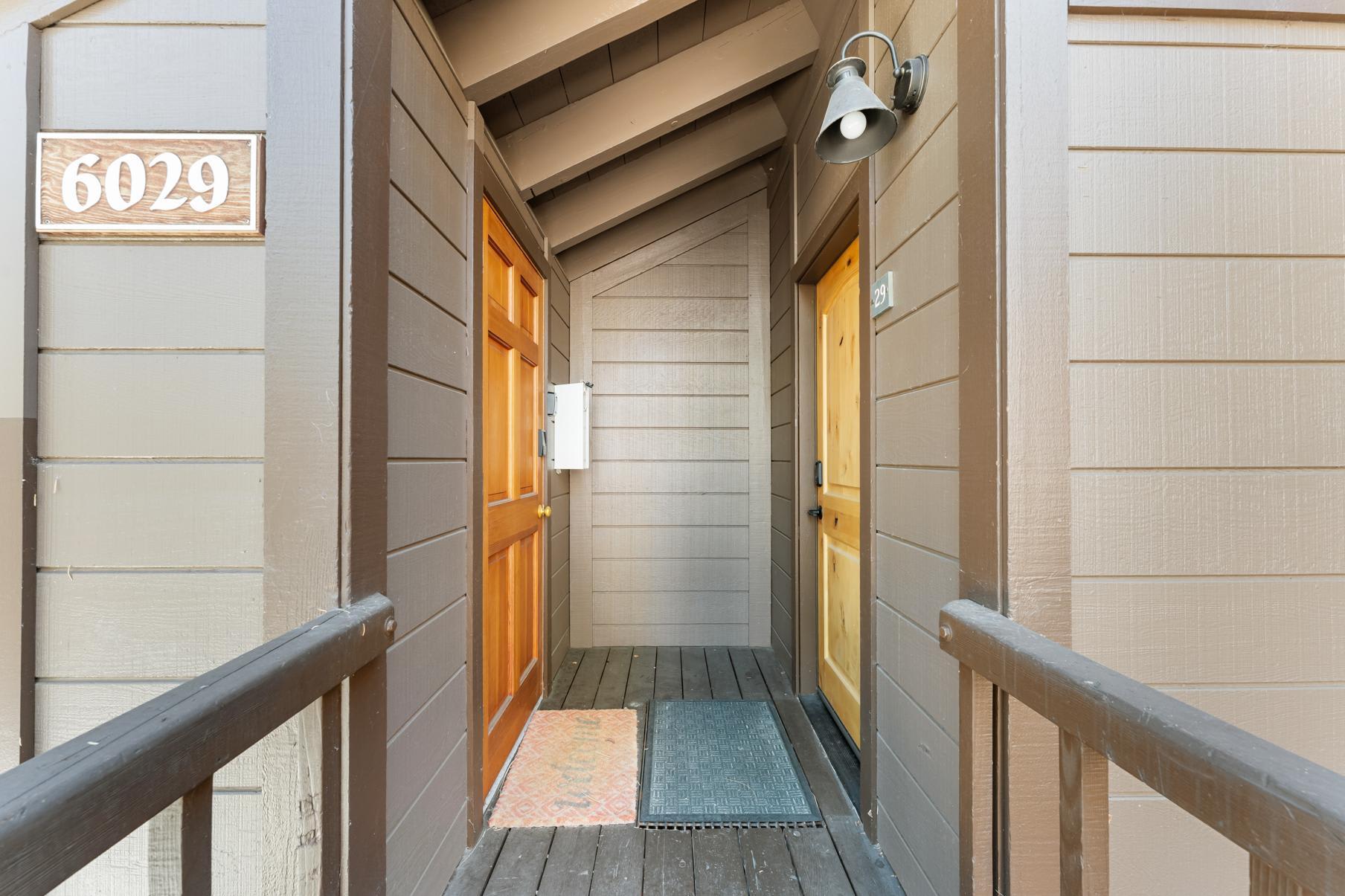 Entryway to a cozy Truckee vacation rental with warm wooden doors and muted exterior walls, featuring unit number 6029.