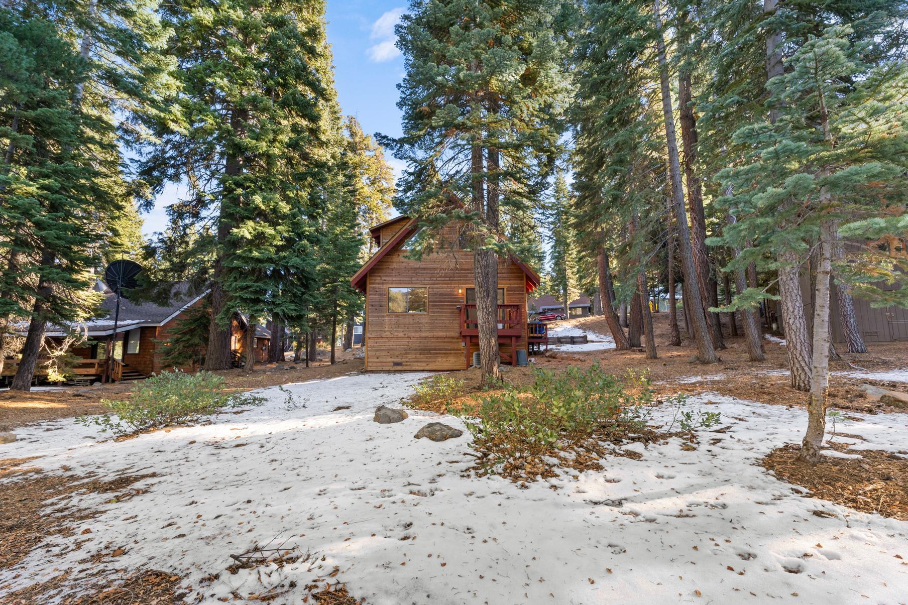 Wooden cabin vacation rental surrounded by trees in snowy Tahoe Vista.