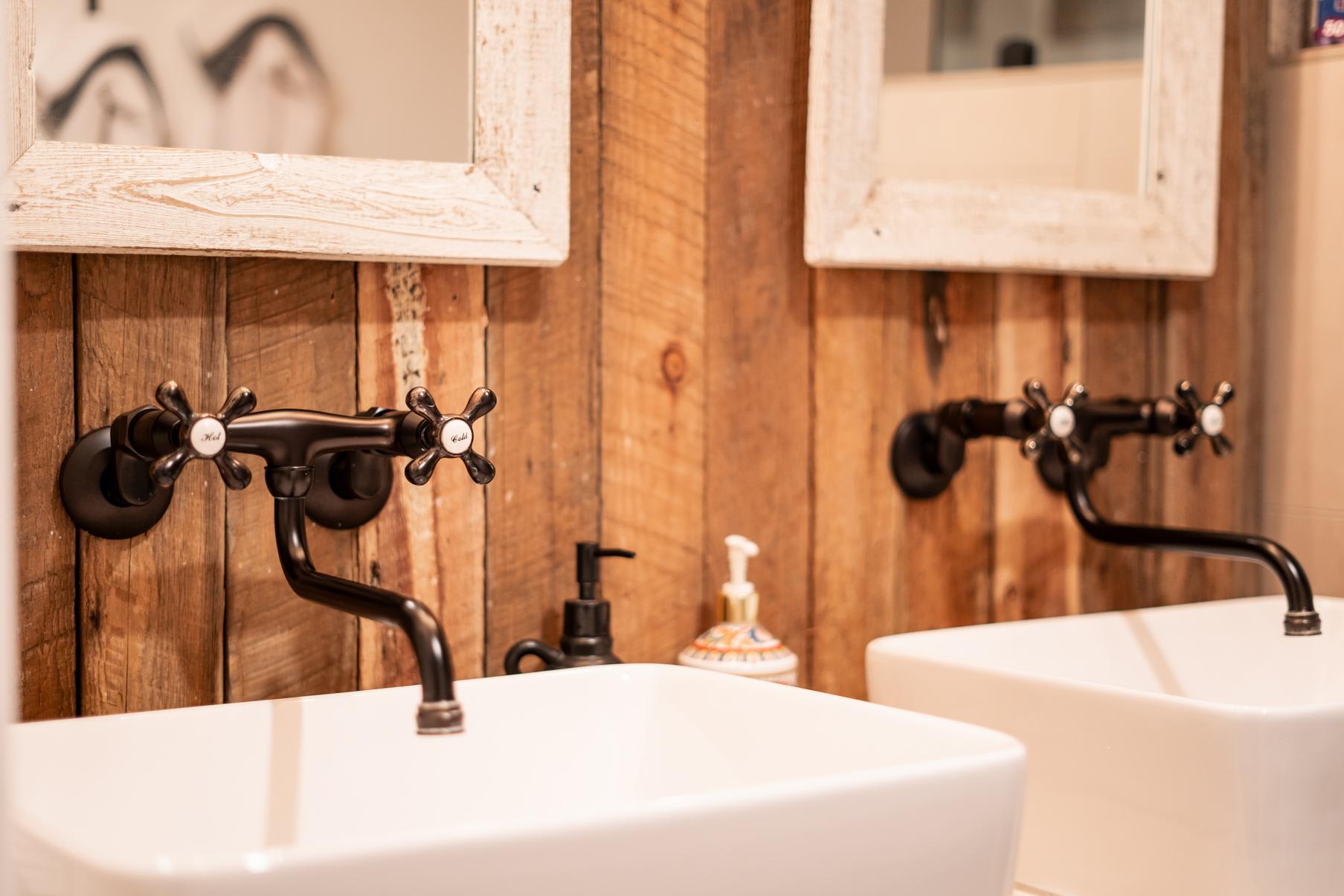 Rustic bathroom sinks with vintage faucets in a Truckee vacation rental.