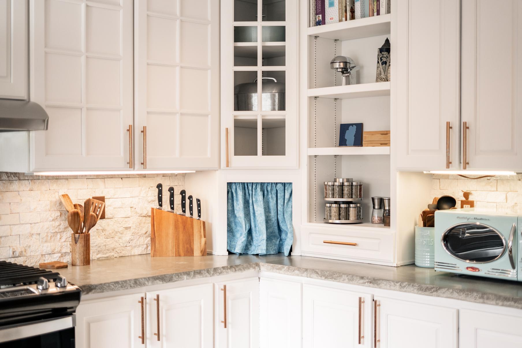 Cozy kitchen in a Truckee vacation rental, featuring white cabinets, stainless appliances, and a stone backsplash.