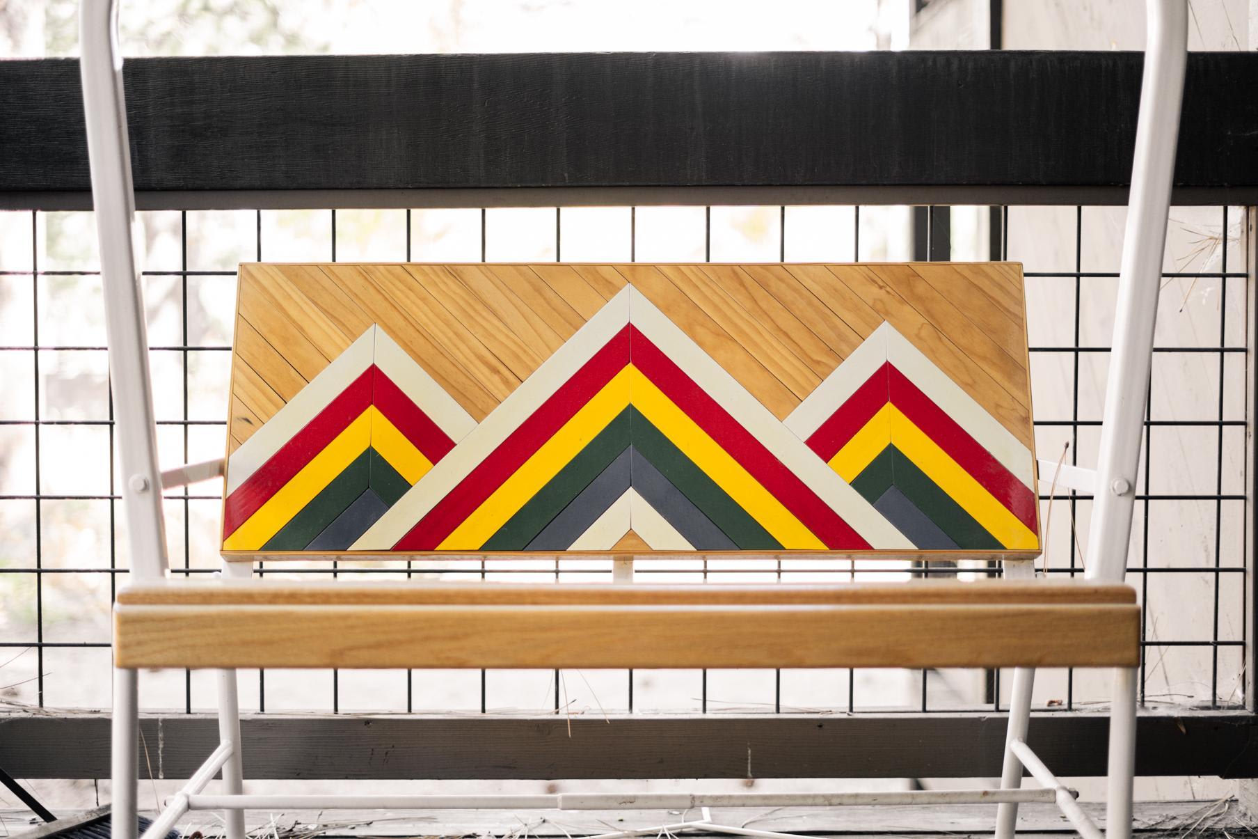 Colorful geometric art on a wooden bench backrest in a Truckee vacation rental.