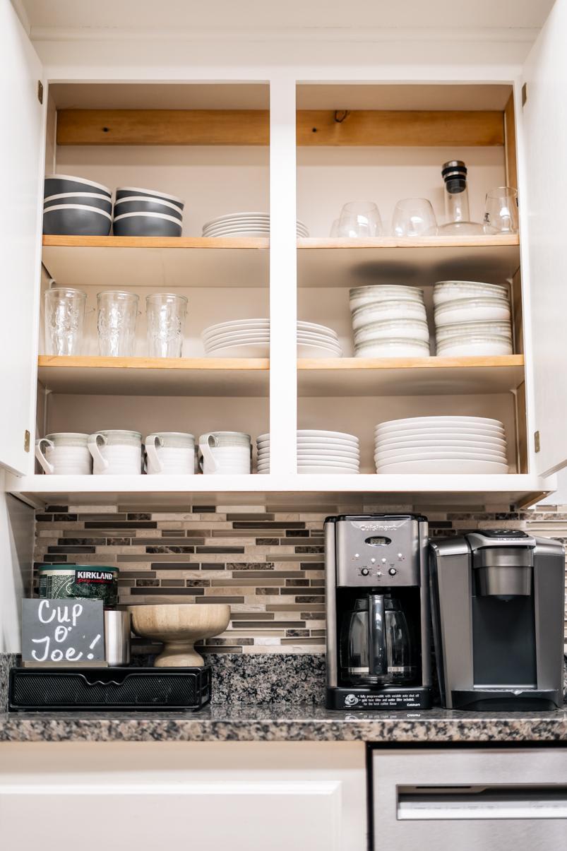 Kitchen area in Truckee vacation rental with open shelves, dishes, and coffee makers on a granite countertop.