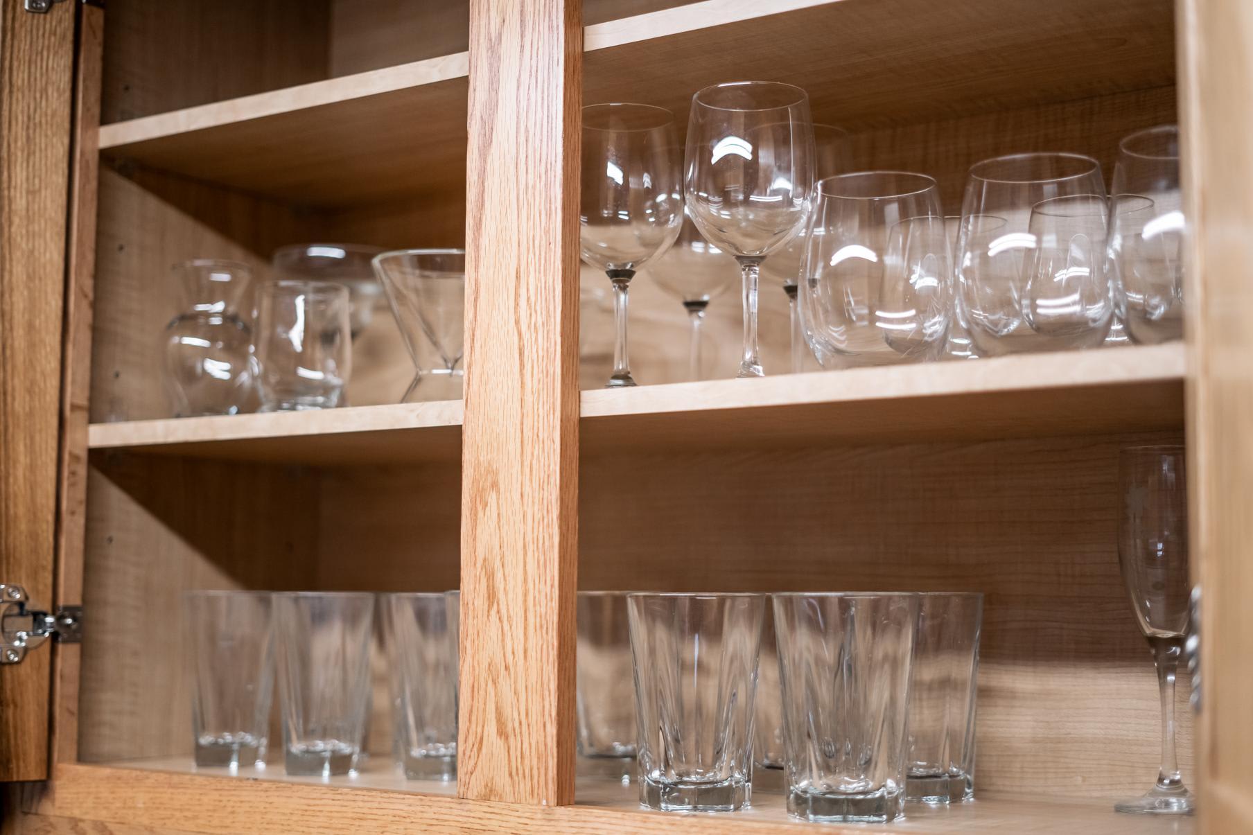 Glassware neatly arranged in wooden cabinets in a Truckee vacation rental kitchen.