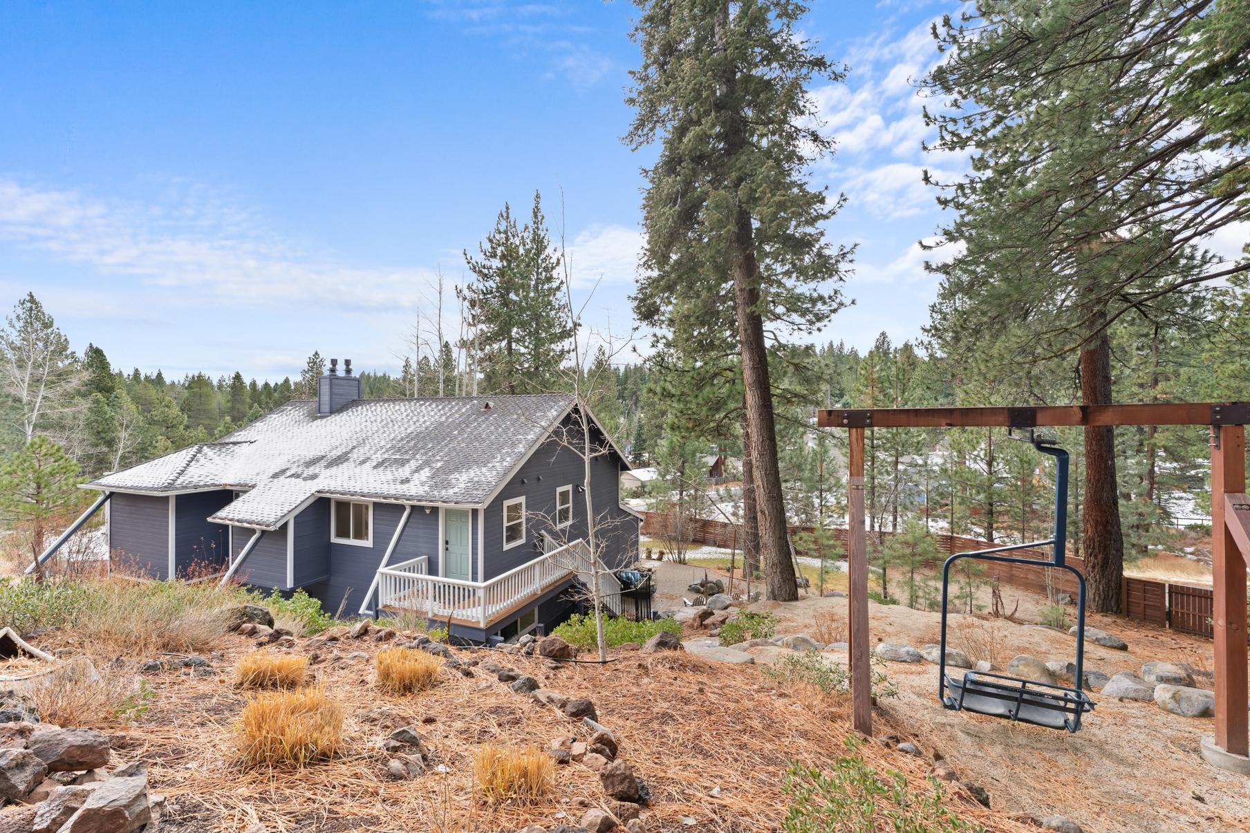 Cozy vacation rental in Truckee surrounded by tall pines, featuring a wooden deck and scenic mountain views.