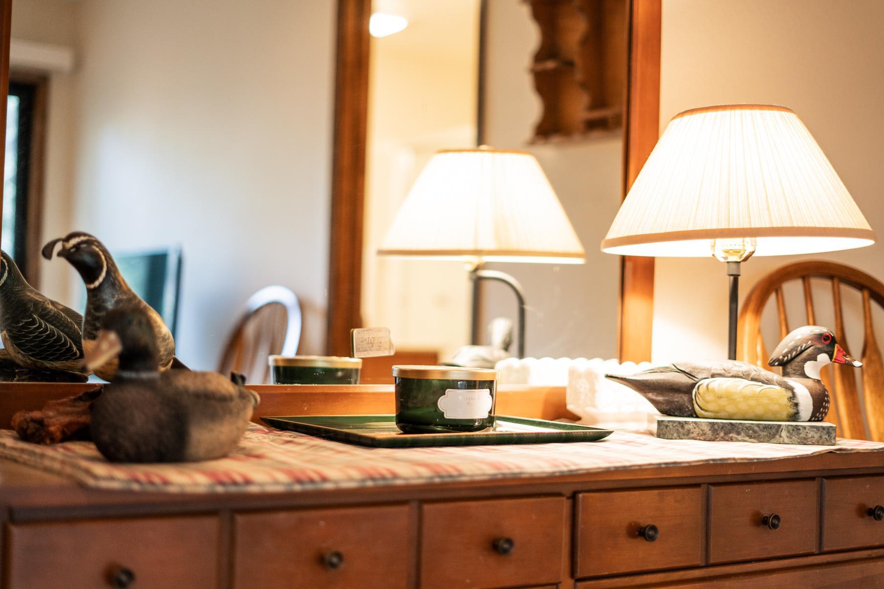 Cozy Truckee vacation rental with wooden dresser, decorative ducks, and a warm lamp, creating a homely ambiance.