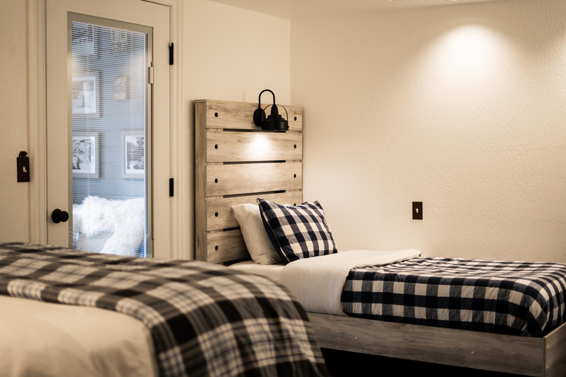 Cozy bedroom in a Truckee vacation rental with plaid bedding and wooden headboard.