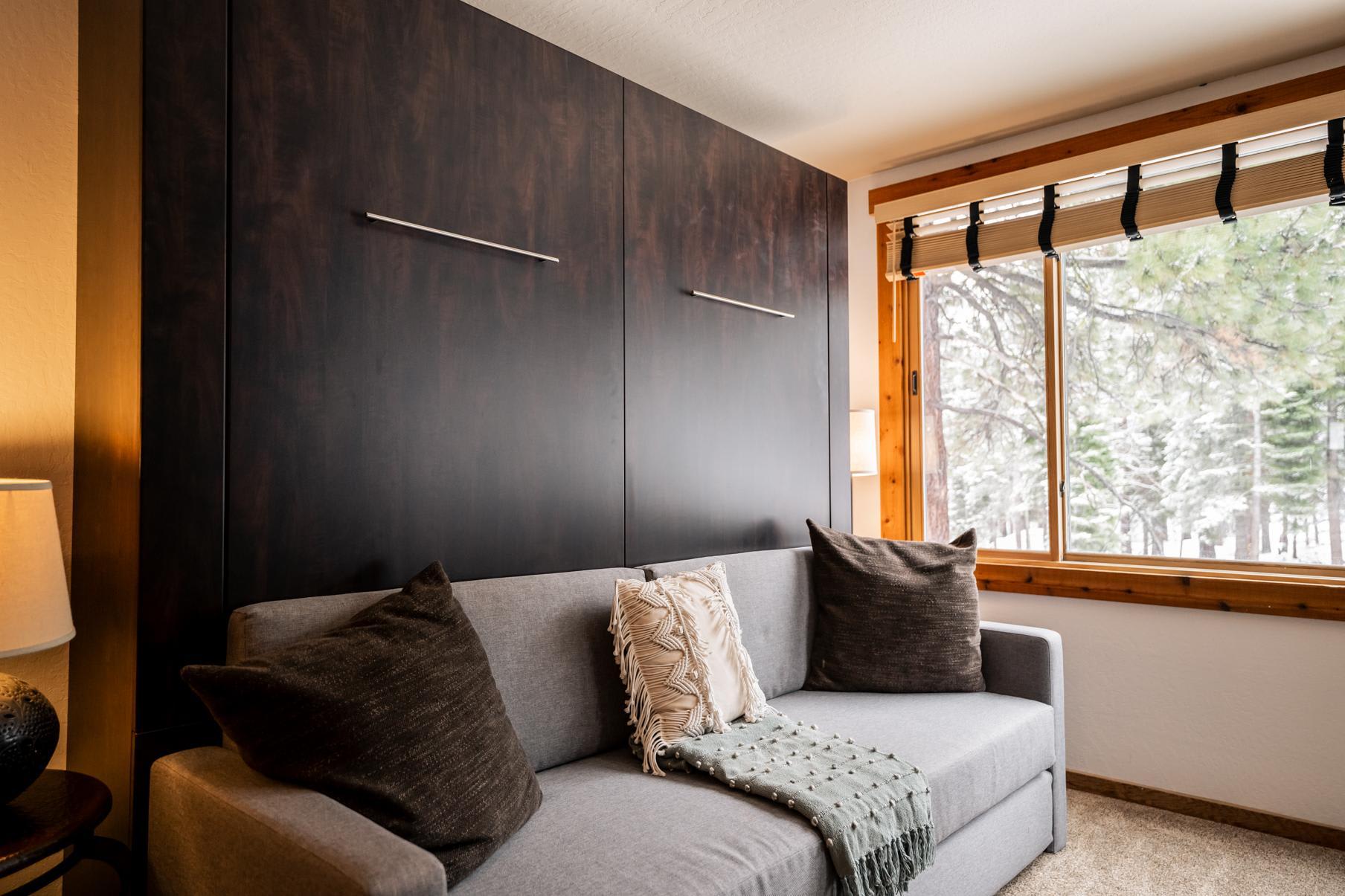 Cozy vacation rental in Truckee with a modern sofa, large window view, and warm decor.