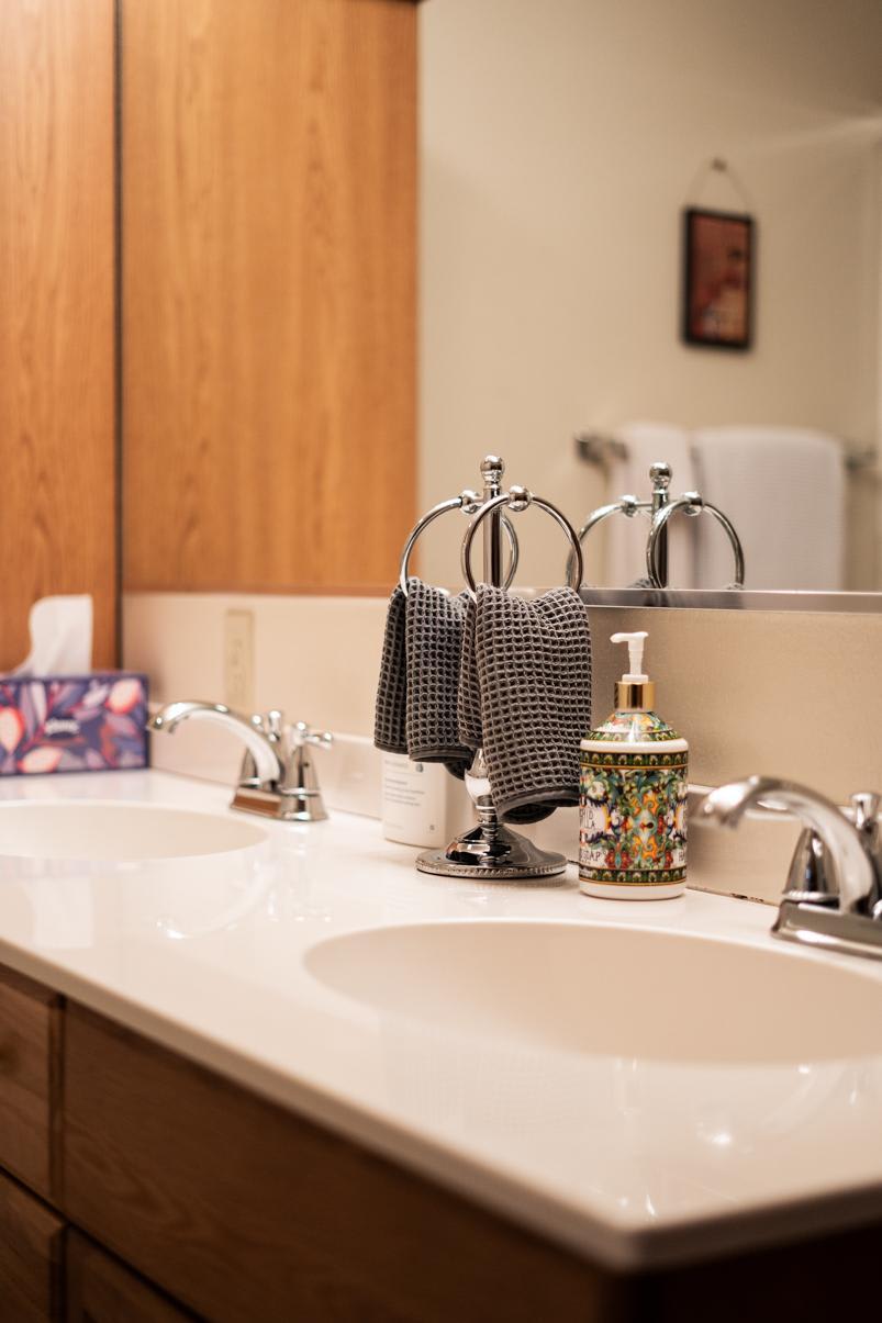 Modern bathroom vanity in Truckee vacation rental, featuring dual sinks, chrome fixtures, and decorative soap dispenser.