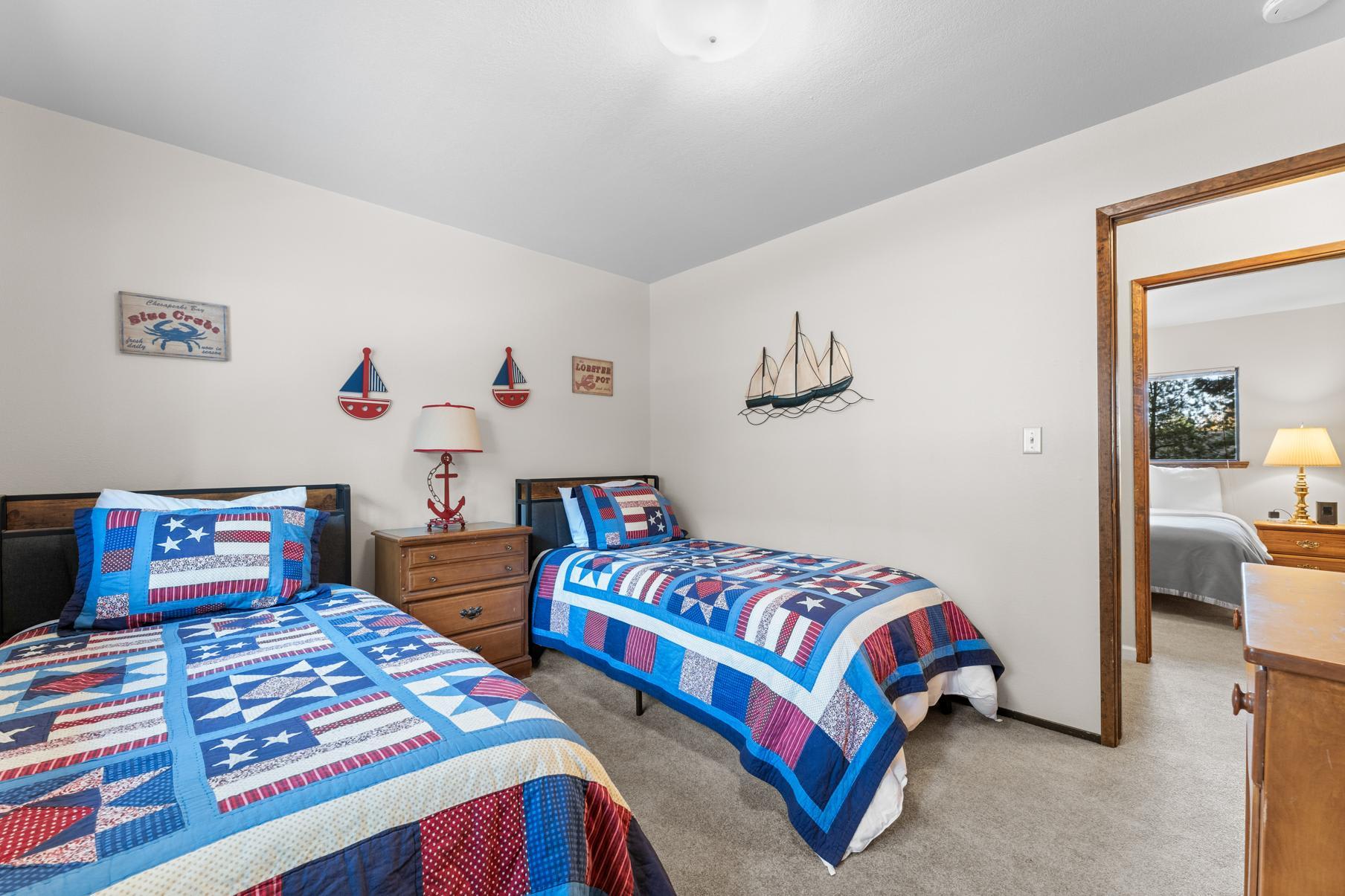 Twin beds with nautical-themed decor in a Truckee vacation rental bedroom.