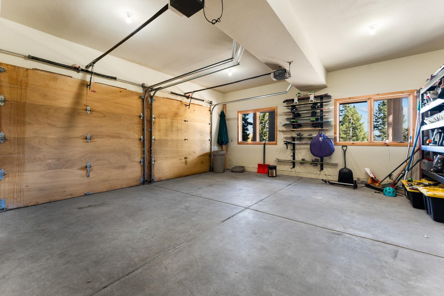 Garage in Truckee vacation rental, featuring a snowboard storage area and views of trees through the windows.